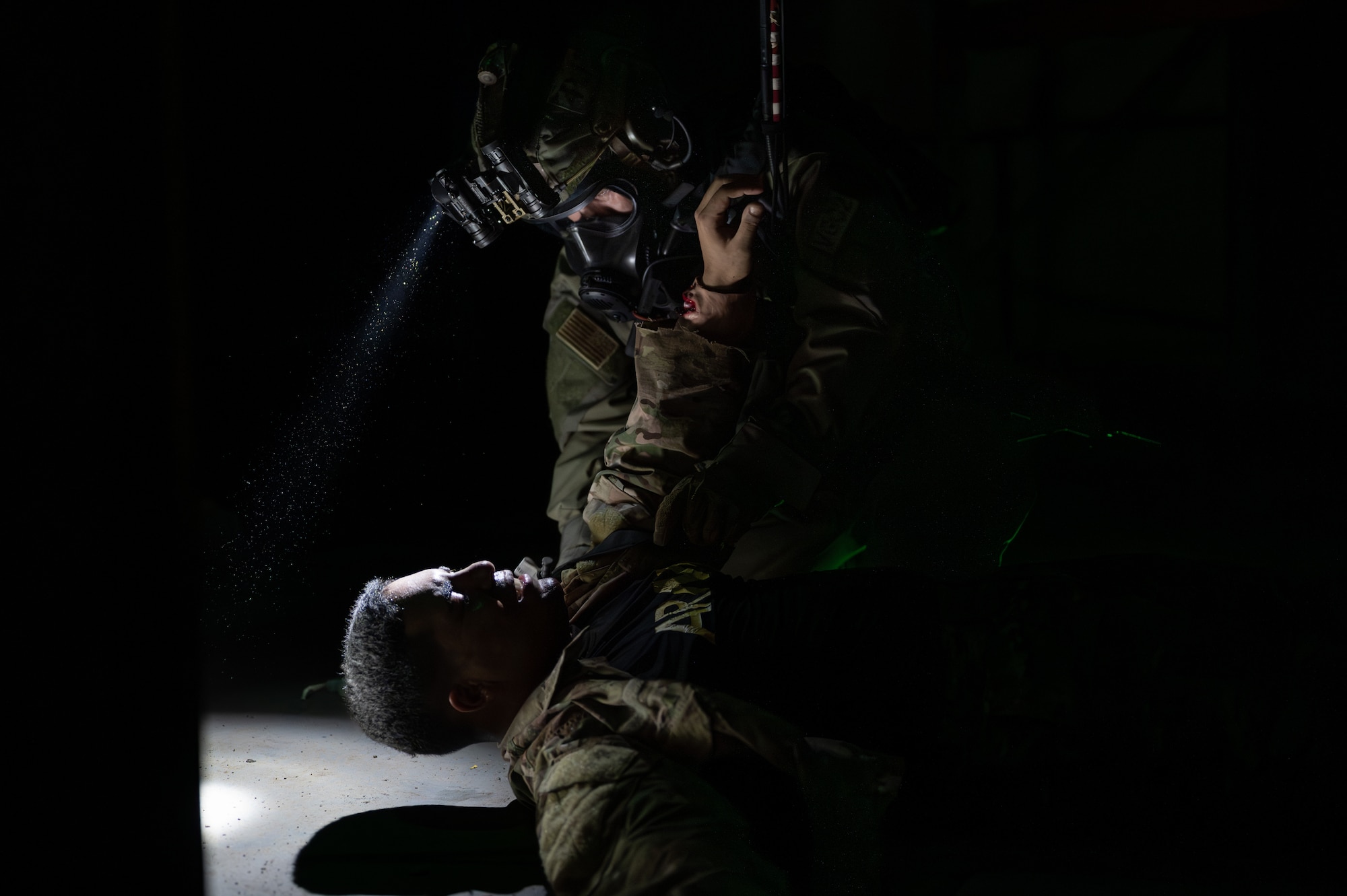 A U.S. Air Force Airman with the 353rd Special Operations Wing evaluates the injuries of a patient involved in a simulated chemical, biological, radiological, nuclear, and explosives mass casualty drill at Kadena Air Base, Japan, Aug. 17, 2023. The operators were evaluated on their rapid action, decision making, and technical performance of medical interventions during the CBRNE scenario-based training. (U.S. Air Force photo by Staff Sgt. Jessi Roth)