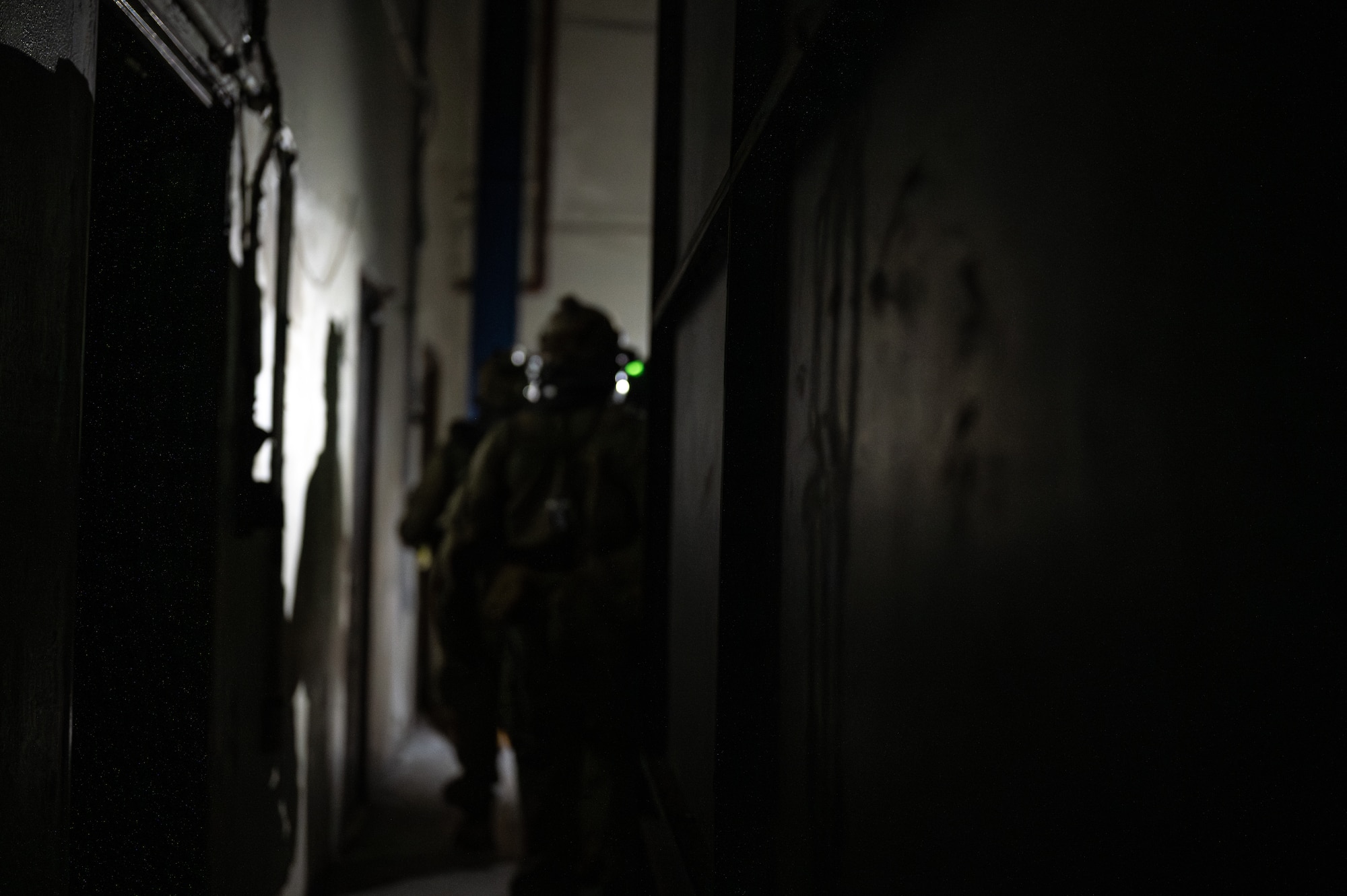 A U.S. Air Force Airman with the 353rd Special Operations Wing stands inside an abandoned factory during a simulated chemical, biological, radiological, nuclear, and explosives mass casualty scenario at Kadena Air Base, Japan, Aug. 17, 2023. The operators were evaluated on their rapid action, decision making, and technical performance of medical interventions during the CBRNE scenario-based training. (U.S. Air Force photo by Staff Sgt. Jessi Roth)