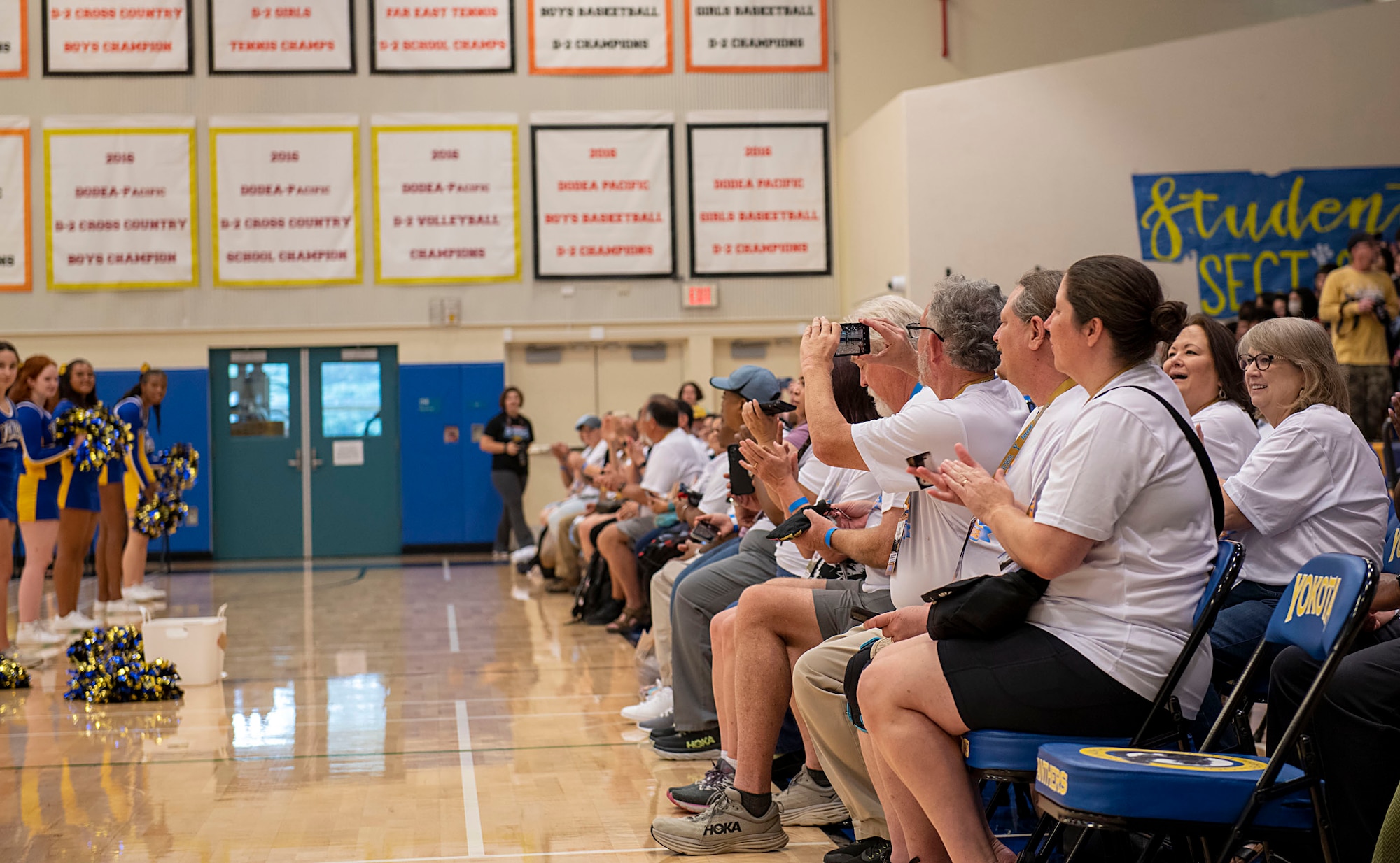 Yokota High School (YHS) alumni watch as the school cheer squad performs
