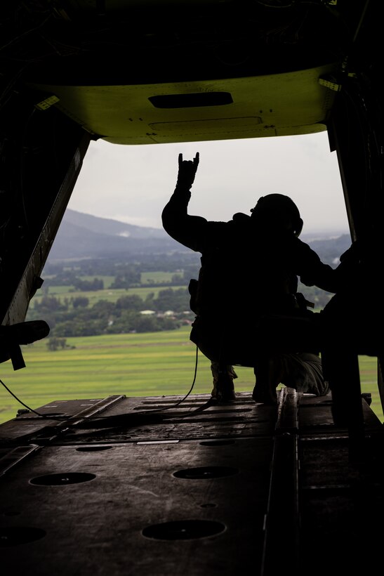 A U.S. Marine Corps crew chief with Marine Medium Tilt-Rotor Squadron 262, gives the hand signal for ‘ready’ in an MV-22 Osprey during Marine Aviation Support Activity (MASA) 23, Basa Air Base, Philippines, July 12, 2023. MASA is a bilateral exercise between the Armed Forces of the Philippines and the U.S. Marine Corps, aimed at enhancing interoperability and coordination focused on aviation-related capabilities. During MASA 23, Filipino and U.S. Marines conduct different training evolutions including live-fire, air assaults, and subject matter expert exchanges across aviation, ground, and logistics capabilities. (U.S. Marine Corps photo by Lance Cpl. Jesse Davis)