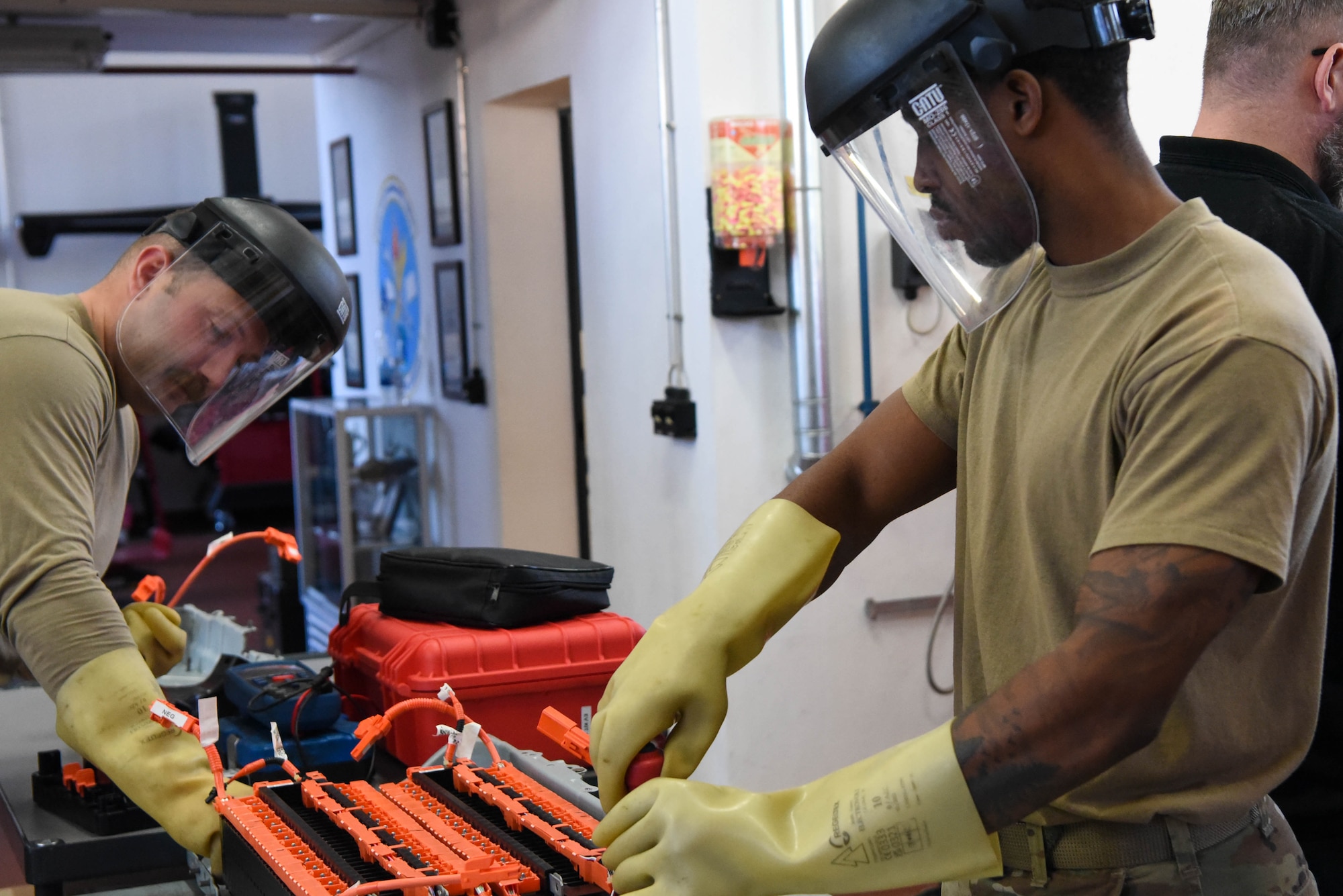 Service members work on car engine.