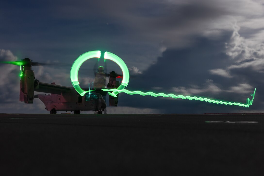 An aircraft prepares to take off from a ship at twilight.