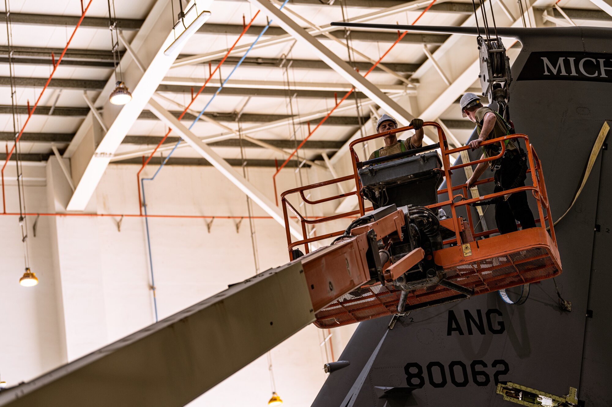 Airman on a lift next to an aircraft