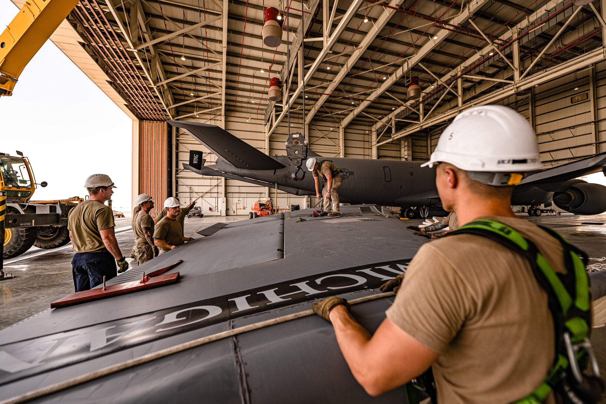 Airmen standing around an aircraft tail fin