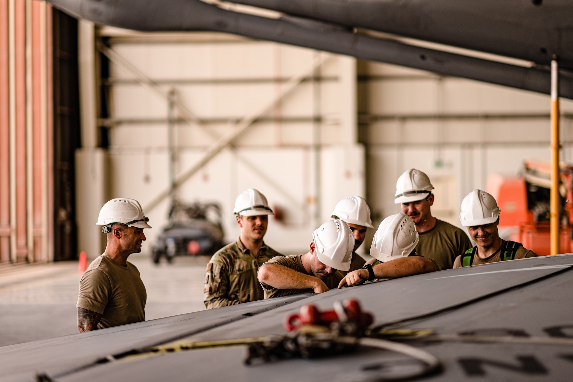 Airmen standing around an aircraft tail fin