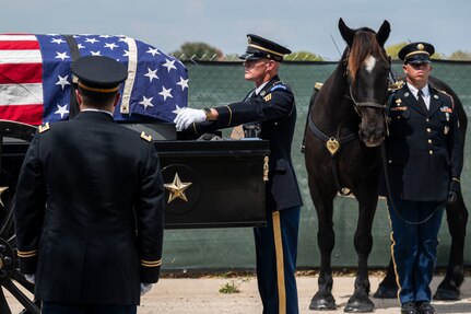 Soldiers preparing to remove casket from wagon.