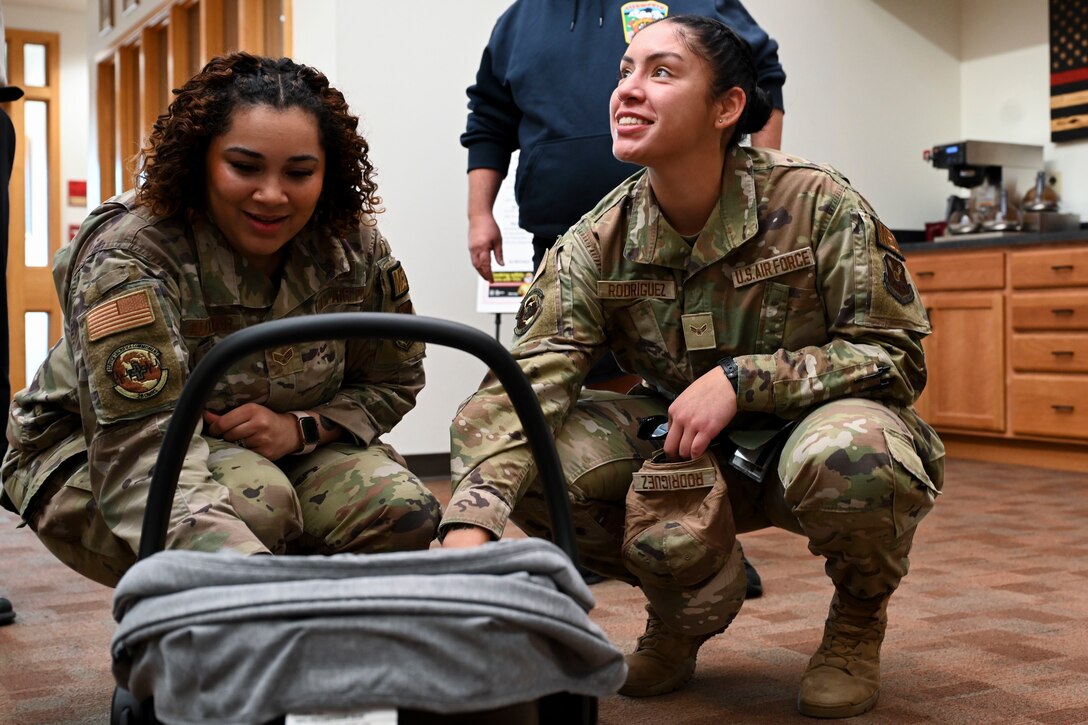 U.S. Air Force Senior Airman Amari Alexander, 28th Operational Medical Readiness Squadron aerospace medical technician, left, and Airman 1st Class Jewel Rodriguez, 28th OMRS aerospace medical technician, interact with the baby they helped deliver at Ellsworth Air Force Base, South Dakota, Sept. 26, 2023.