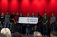 Tom Ross, Mayor of the city of Minot, North Dakota, and other civic leaders pose for a photo with Team Minot leaders during Norsk Hostfest in the city of Minot, North Dakota, Sept. 30, 2023. The boarding pass represented donations used to send Team Minot Airmen home for the holidays.