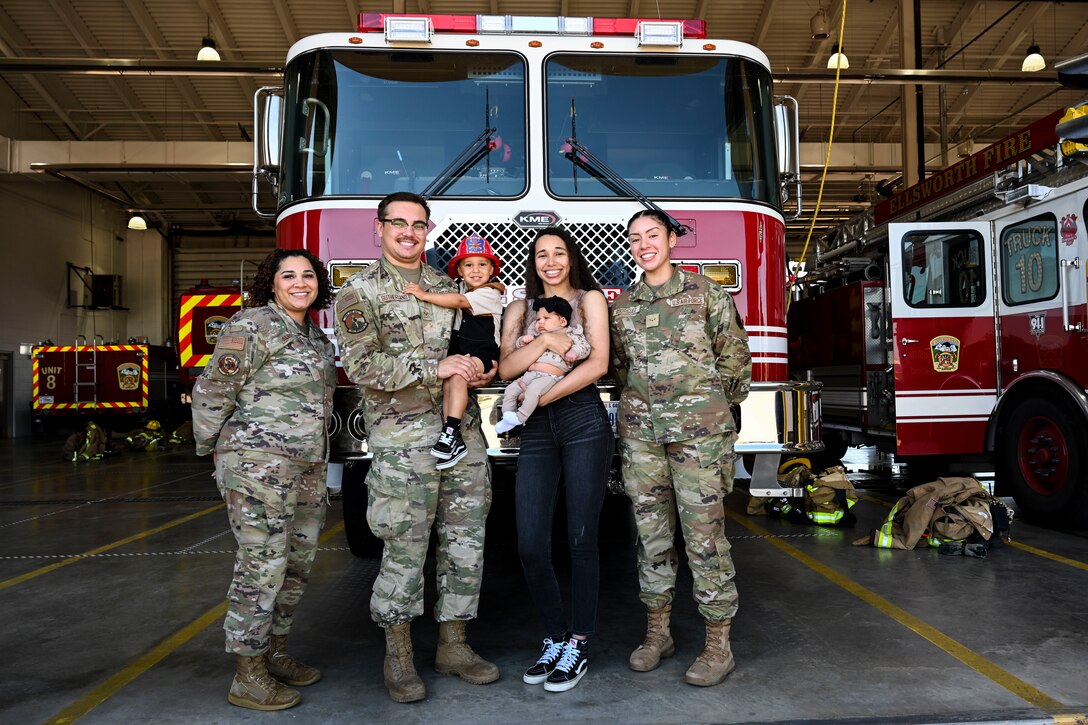 U.S. Air Force Senior Airman Derek Sutherland and his wife Tatiyanna Sutherland hold their children Daxtyn and Taytum, they are flanked by Senior Airman Amari Alexander and Airman 1st Class Jewel Rodriguez, 28th Operational Medical Readiness Squadron aerospace medical technicians at Ellsworth Air Force Base, Sept. 26, 2023.