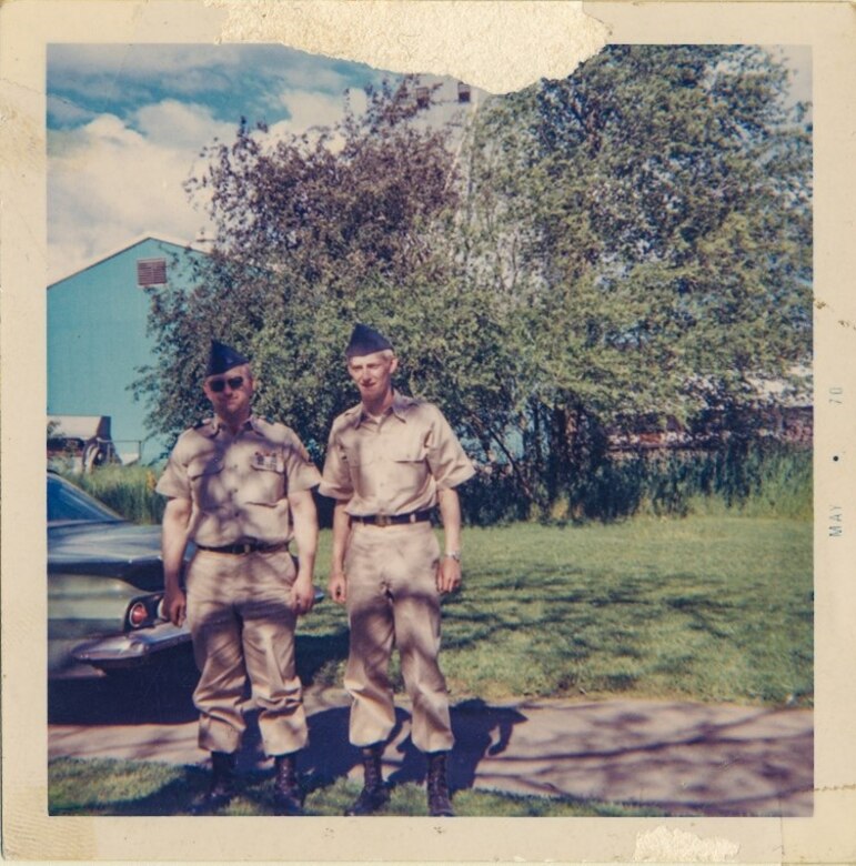 Two men stand in army uniforms