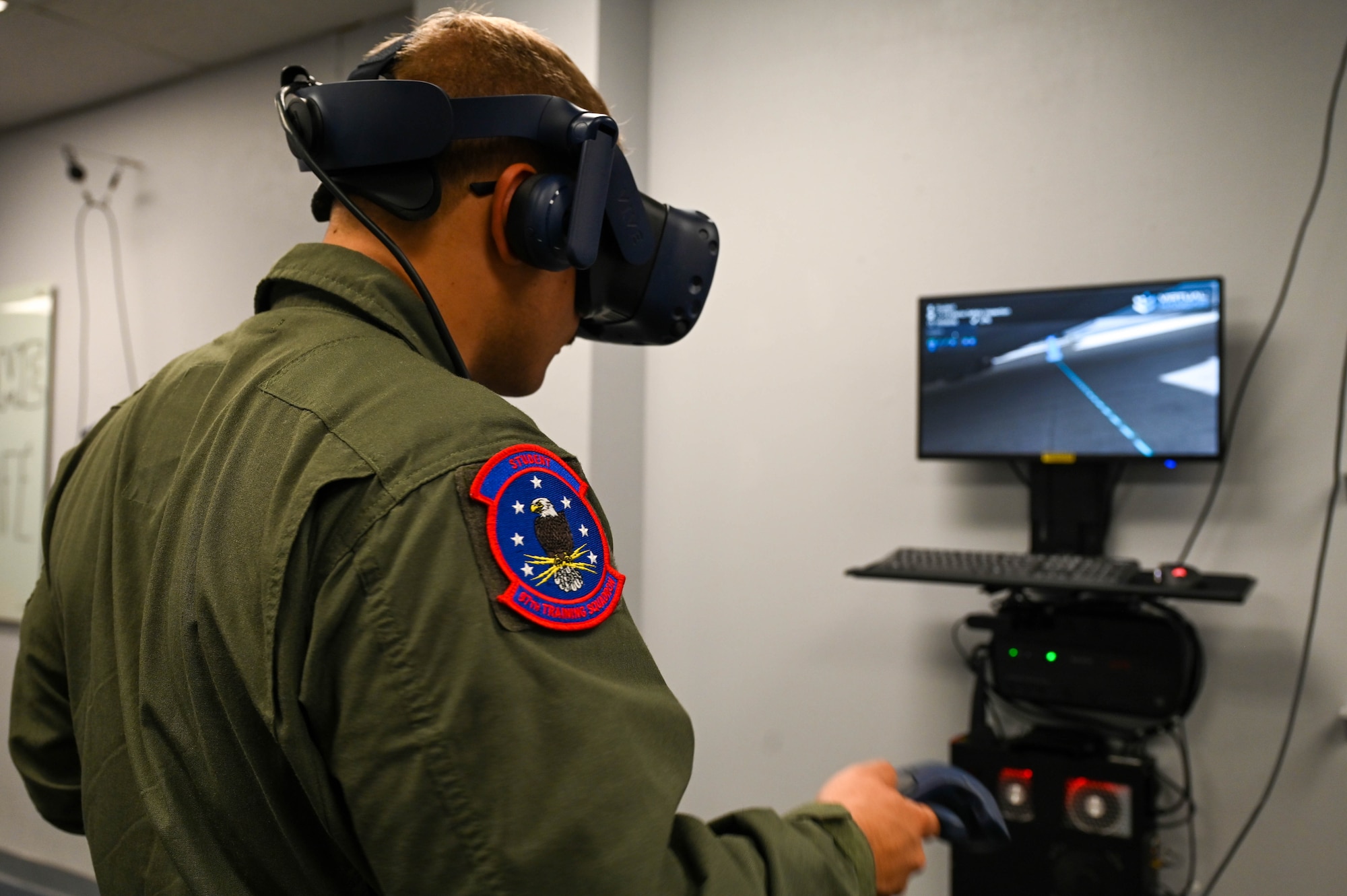 U.S. Air Force Airman Joseph Darisse, 97th Training Squadron loadmaster student, performs an external check on a C-17 Globemaster III using a virtual reality headset in the virtual reality cafe at Altus Air Force Base, Oklahoma, Sept. 27, 2023. With 2110 graduates during fiscal year 2023, the squadron celebrates its highest number of student graduates in 16 years. (U.S. Air Force photo by Airman 1st Class Kari Degraffenreed
