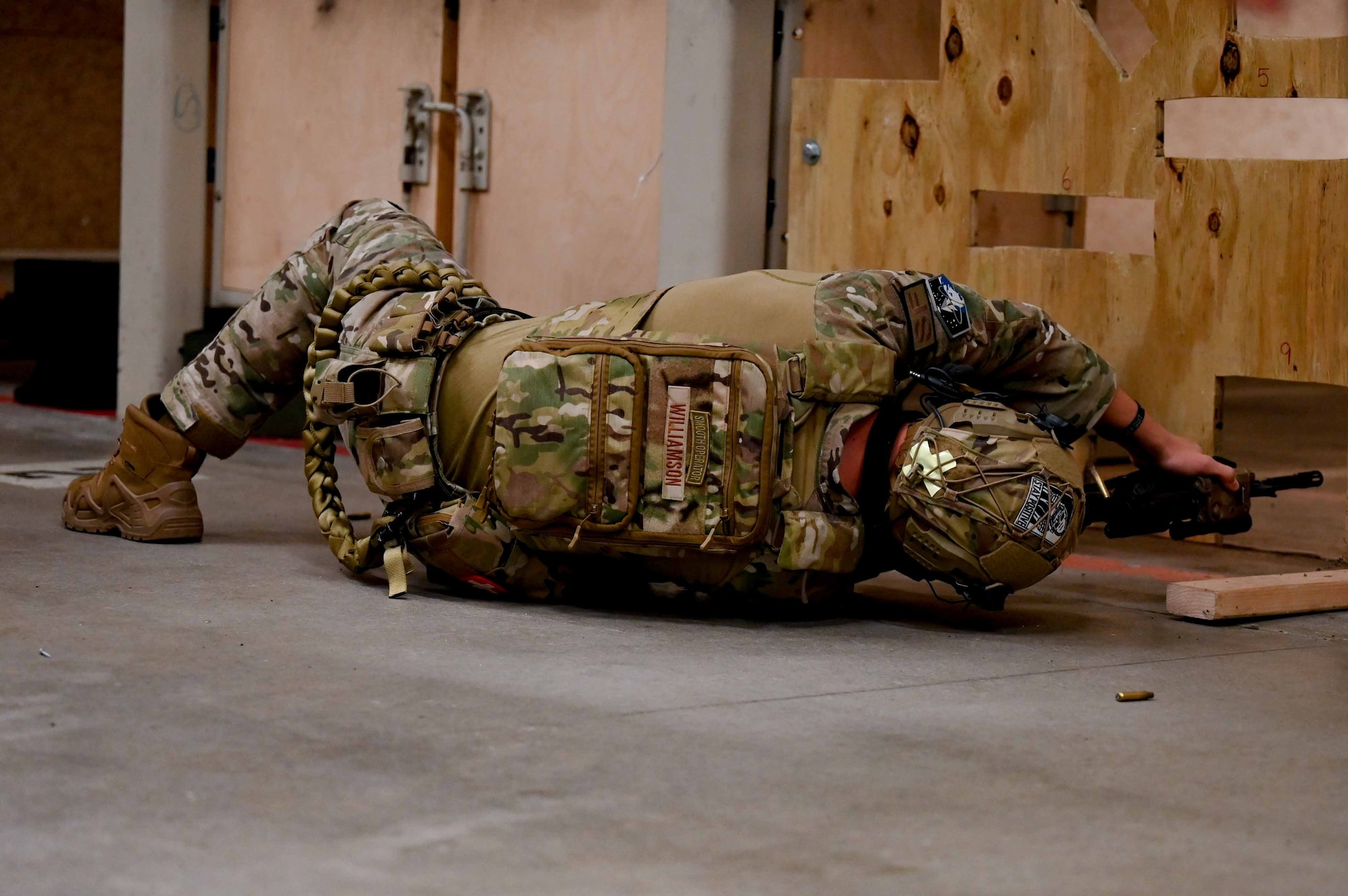 460th Security Forces Squadron member aims weapon at target