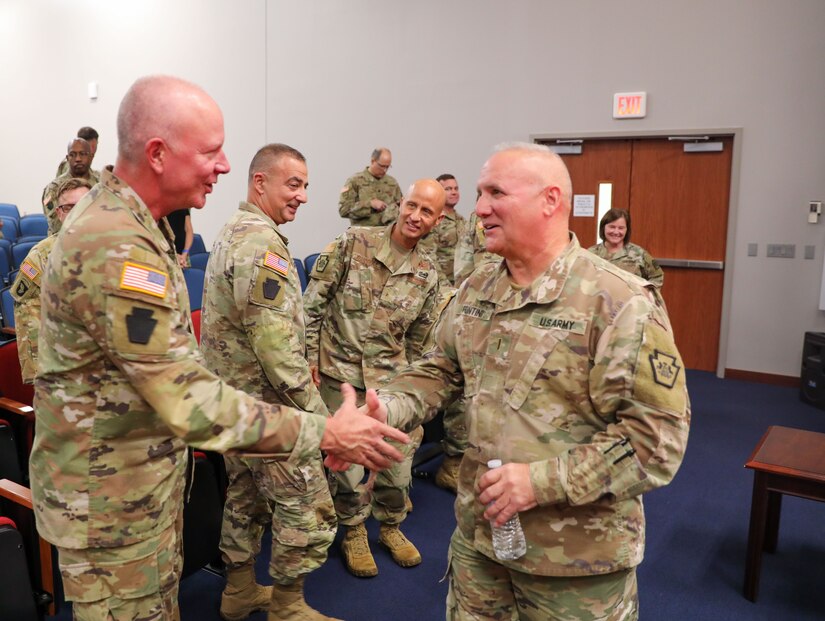 Maj. Gen. Mark Schindler, Pennsylvania's adjutant general, congratulates outgoing Chief Warrant Officer 5 James Fontini, the Pennsylvania Army National Guard’s command chief warrant officer, who is retiring after 41 years of service. Chief Warrant Officer 5 Darren Dreher took over as CCWO Oct. 5, 2023, in a change of responsibility ceremony at Fort Indiantown Gap. (U.S. Army National Guard photo by Sgt. 1st Class Zane Craig)