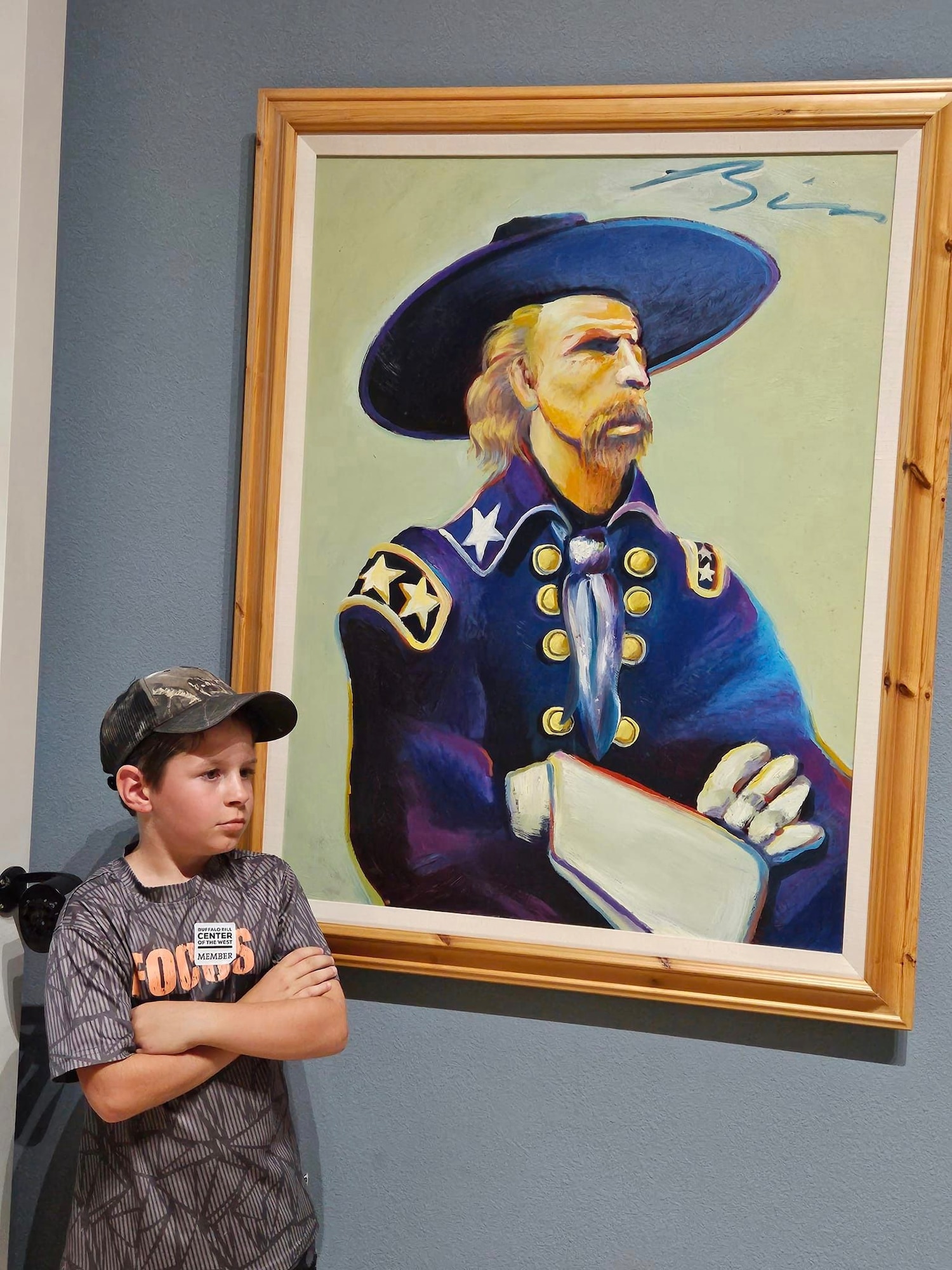 young man standing next to a painting of Gen. George Custer