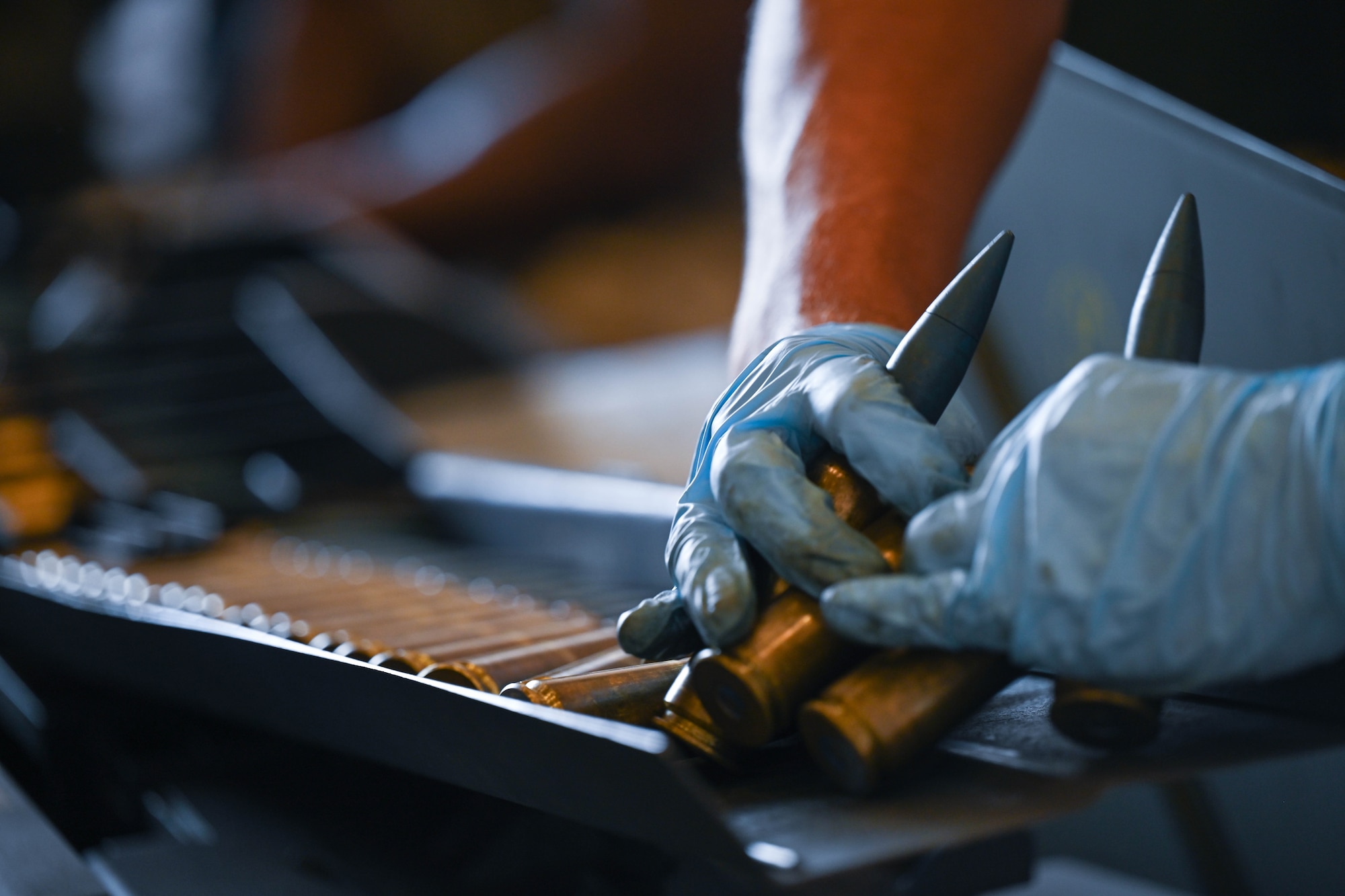 An Airman from the 15th Maintenance Squadron munitions flight, loads 20 mm rounds into a Universal Ammunition Loading System during a training exercise at Joint Base Pearl Harbor-Hickam, Hawaii, Aug. 2, 2023. The UALS increases efficiency when loading an aircraft munitions system. (U.S. Air Force photo by Senior Airman Makensie Cooper)