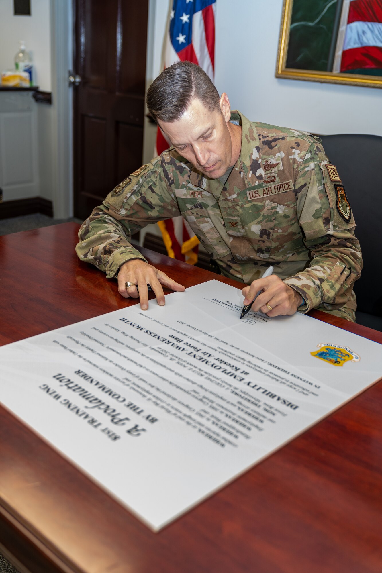 U.S. Air Force Col. Billy Pope Jr., 81st Training Wing commander, signs the National Disability Employment Month proclamation at Keesler Air Force Base, Mississippi, Oct. 05, 2023.