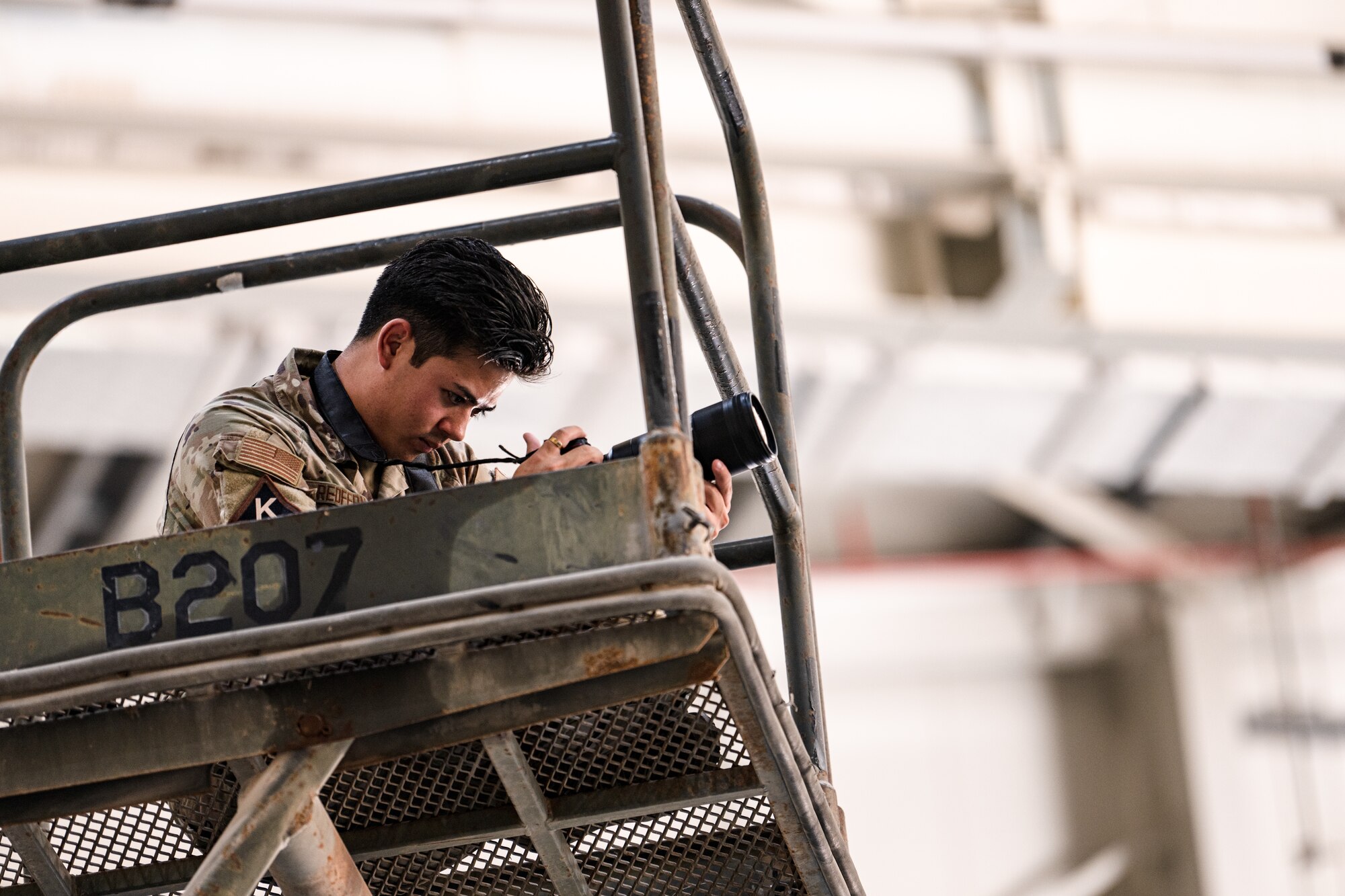 Airman photographing from a maintenance stand