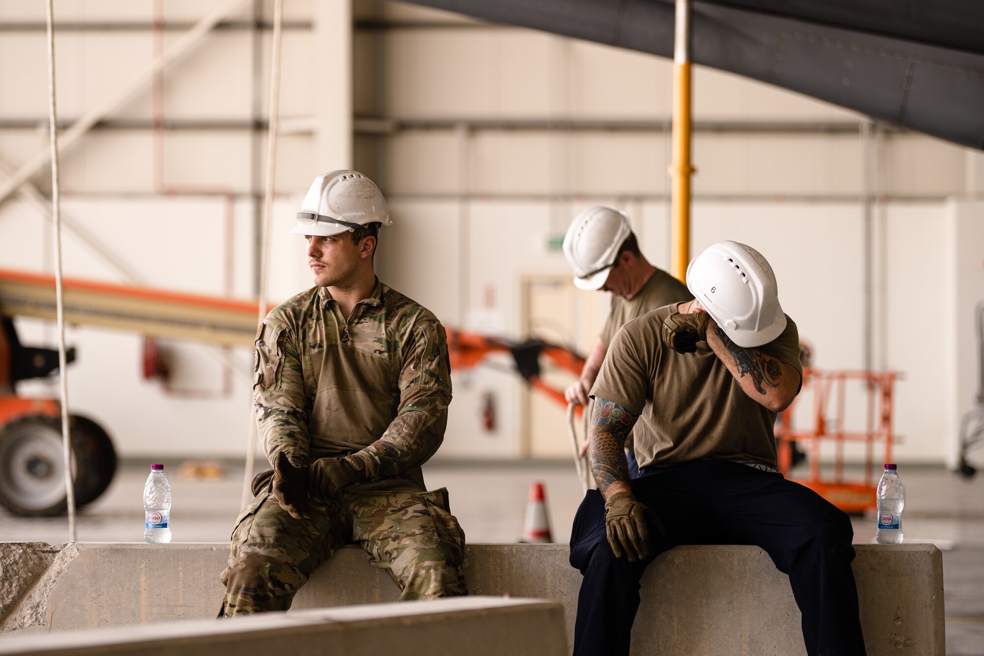 Airmen sitting on a jersey barrier