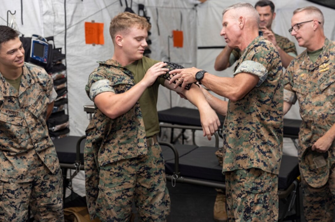 The 36th Assistant Commandant of the Marine Corps, Gen. Eric M. Smith, right, fits a 3D printed cast to the arm of Lance Cpl. Micah Mosley, a network administrator from 1st Marine Logistics Group (MLG), 1st Marine Division, I Marine Expeditionary Force (MEF), on Camp Pendleton, California, August 17, 2023. The cast was manufactured by 1st Medical Battalion. General Smith Visited 1st MLG as part of a command tour and to observe the logistical capabilities of I MEF. (U.S. Marine Corps photo by Sgt. Rachaelanne Woodward)