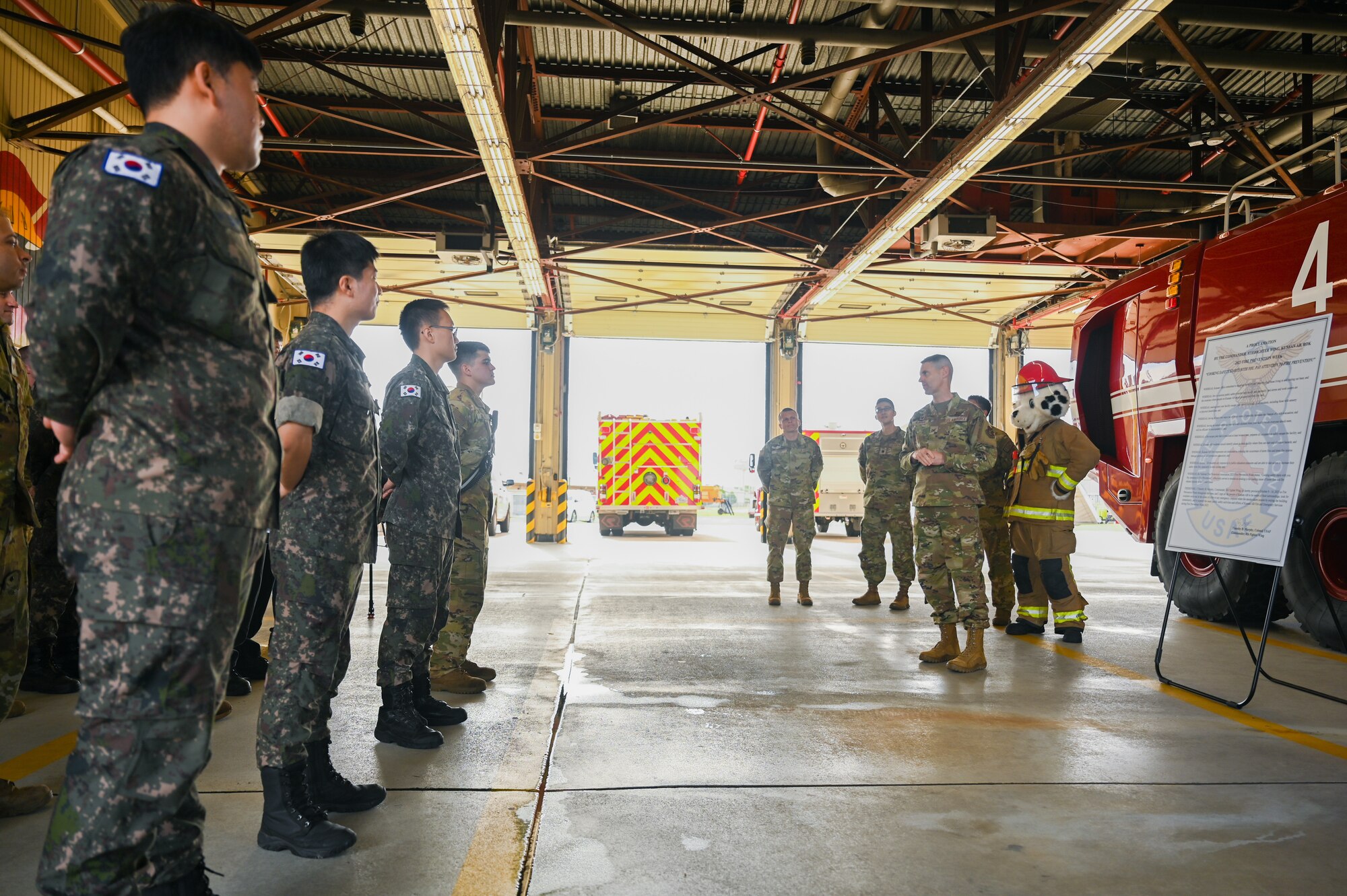 Kunsan Air Base firefighters stand in formation as 8th Fighter Wing commander signs the installation’s 2023 Fire Prevention Week proclamation at Kunsan AB