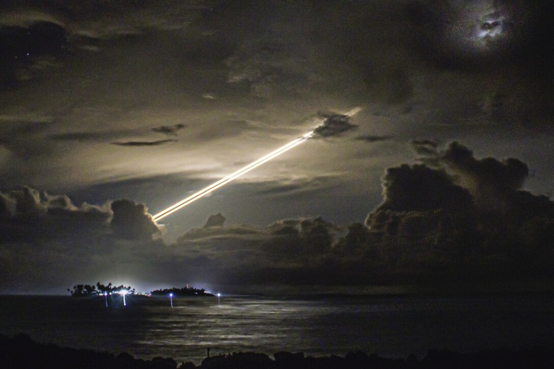 A missile leaves a bright streak of light against a dark sky.