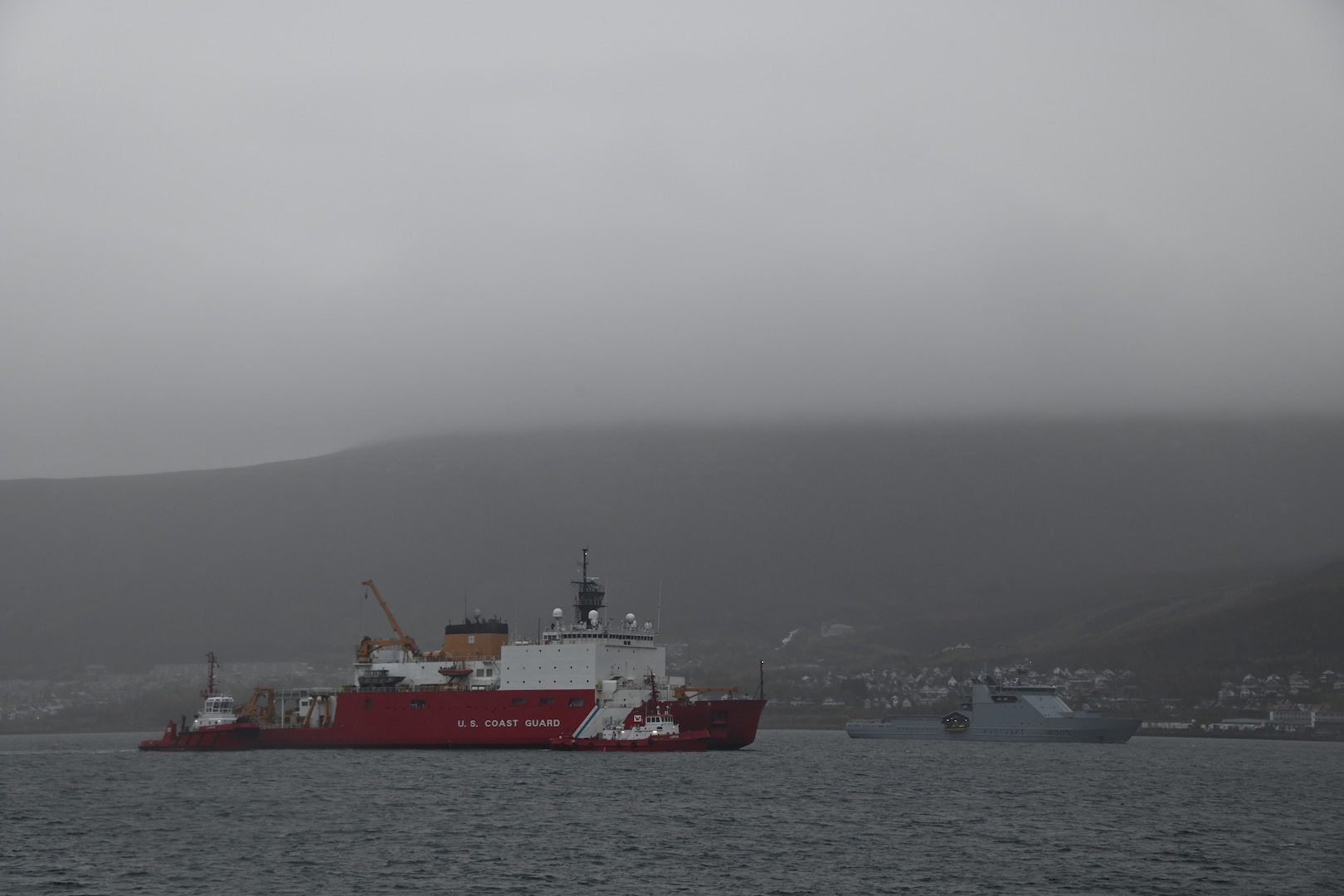 The U.S. Coast Guard Cutter Healy (WAGB 20) transits the Tromsøysundet Strait alongside the Norwegian Coast Guard Vessel Svalbard near Tromsø, Norway, Oct. 1, 2023. The U.S. shares a decades-long stalwart partnership with Norway built upon shared values, experiences, and vision. (U.S. Coast Guard photo by Senior Chief Petty Officer Charly Tautfest)