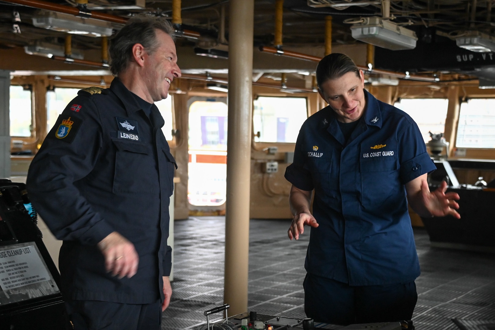 U.S. Coast Guard Capt. Michele Schallip, commanding officer of the U.S. Coast Guard Cutter Healy (WAGB 20), discusses the Healy’s bridge systems to Commander Geir-Martin Leinebø, commanding officer of the Norwegian Coast Guard Vessel Svalbard, after the Healy moored in Tromsø, Norway, Oct. 1, 2023. The U.S. and Norwegian Coast Guards conducted joint exercises in the Barents Sea to develop cooperation, interoperability, and build partnerships among the two coast guards. (U.S. Coast Guard photo by Senior Chief Petty Officer Charly Tautfest)