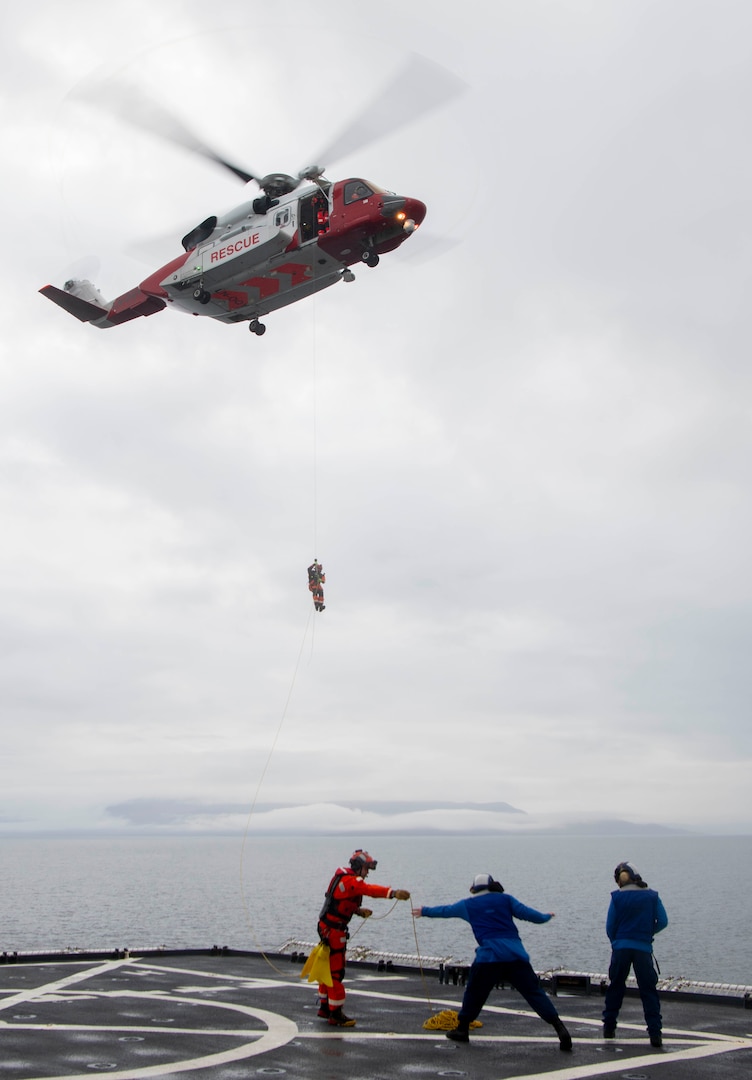 Emergency responders are lowered from a Norwegian land-based rescue helicopter onto U.S. Coast Guard Cutter Healy’s (WAGB 20) flight deck during a search and rescue exercise in Fugloysund in northern Norway on Sept. 30, 2023. Exercises like this builds interoperability with allies and partners to respond to emergencies in the challenging Arctic region.

(U.S. Air Force photo by Airman 1st Class Norman D. Enriquez)
