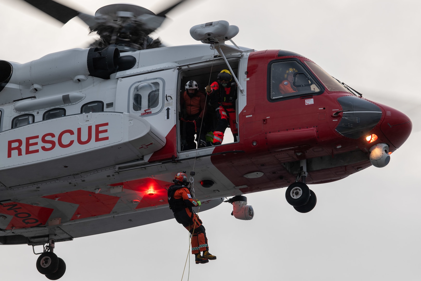 A Norwegian emergency responder rappels from a Norwegian land-based rescue helicopter onto U.S. Coast Guard Cutter Healy’s (WAGB 20) flight deck during a search and rescue exercise in the Fugloy Sound in northern Norway on Sept. 30, 2023. The exercise was conducted to develop interoperability with allies and to quicken response times to emergencies in the Arctic region. (U.S. Department of Defense photo by Sgt. Carter Acton)