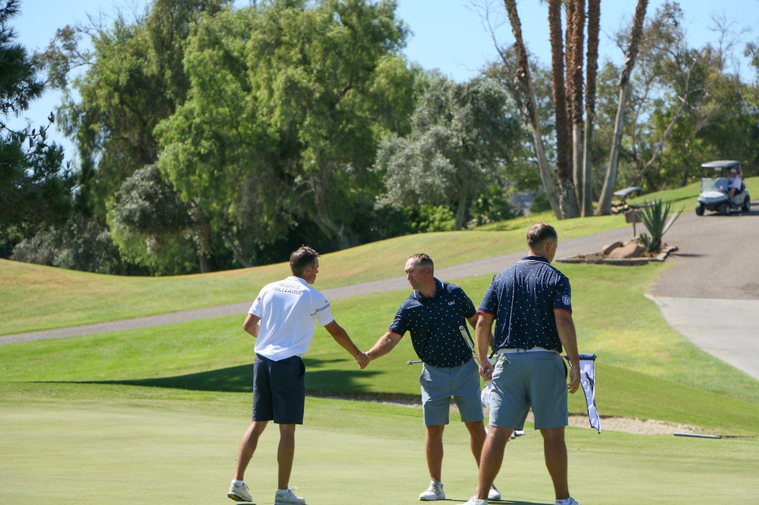 From left to right: France's Nicolas Muller, USA Marine Staff Sgt. David Banks of MCAS New River, N.C. and Navy Lt. Jacob Meloche of Naval Base San Diego, Calif. finish up at the 18th hole during the third round of golf at the 14th Edition of the Conseil International du Sport Militaire (CISM) World Military Golf Championship held at the Admiral Baker Golf Course in San Diego, Calif., hosted by Naval Base San Diego, Calif.  Nations from Bahrain, Canada, Denmark, Dominican Republic, Estonia, France, Germany, Ireland, Italy, Kazakhstan, Kenya, Latvia, Netherlands, Sri Lanka, Tanzania, Zimbabwe, and host USA compete for gold. Department of Defense Photo by Ms. Theresa Smith - Released.