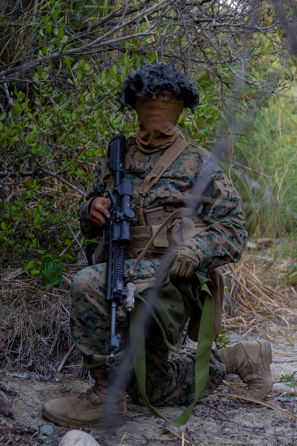 A U.S. Marine with Alpha Company, Infantry Training Battalion, School of Infantry - West, kneels before night patrolling as part of the tenth week of the Infantry Marine Course on Marine Corps Base Camp Pendleton, California, April 1, 2021. IMC is a 14-week pilot course designed to create better trained and more lethal entry-level infantry Marines prepared for near-peer conflicts. The course uses a redesigned learning model for students intended to develop their capabilities for independent and adaptive thought and action. The program of instruction for IMC has been in development for a year and follows guidance from the 2019 Commandant's Planning Guidance and Force Design 2030. (U.S. Marine Corps photo by Lance Cpl. Kerstin Roberts)