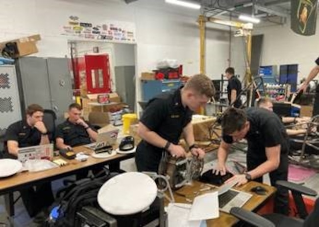 Engineers work on a project at a table.