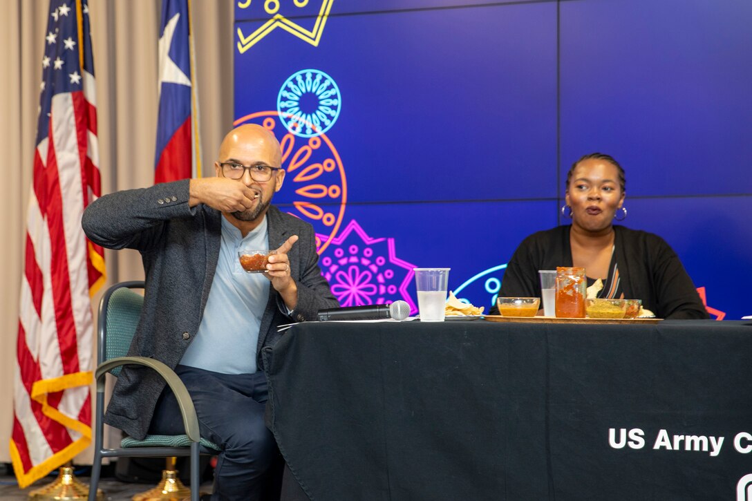 Carlos Gomez, Hispanic Employment Program manager for the U.S. Army Corps of Engineers (USACE) Galveston District (SWG), takes a generous helping of home made salsa during the district's Hispanic Heritage Month Observance, October 5, 2023. Fellow panelist Kendell Barber looks on in surprise. The panelists presented ‘¡Caliente!: A presentation on the origins of spicy food’ as part of SWG's Hispanic Heritage Month observance. Gomez and fellow panelists taste tested a variety of homemade salsas and hot sauces provided by their SWG colleagues.