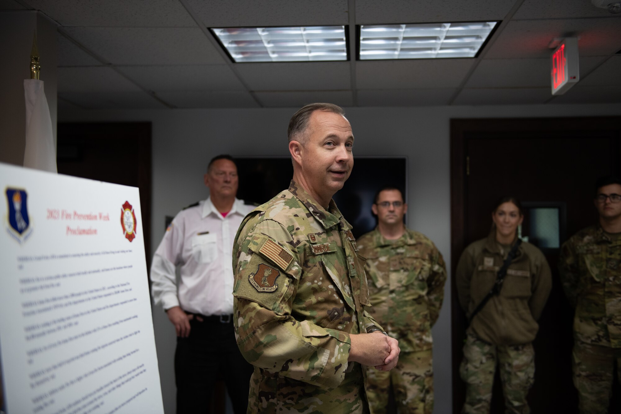 People in green uniforms stand around talking