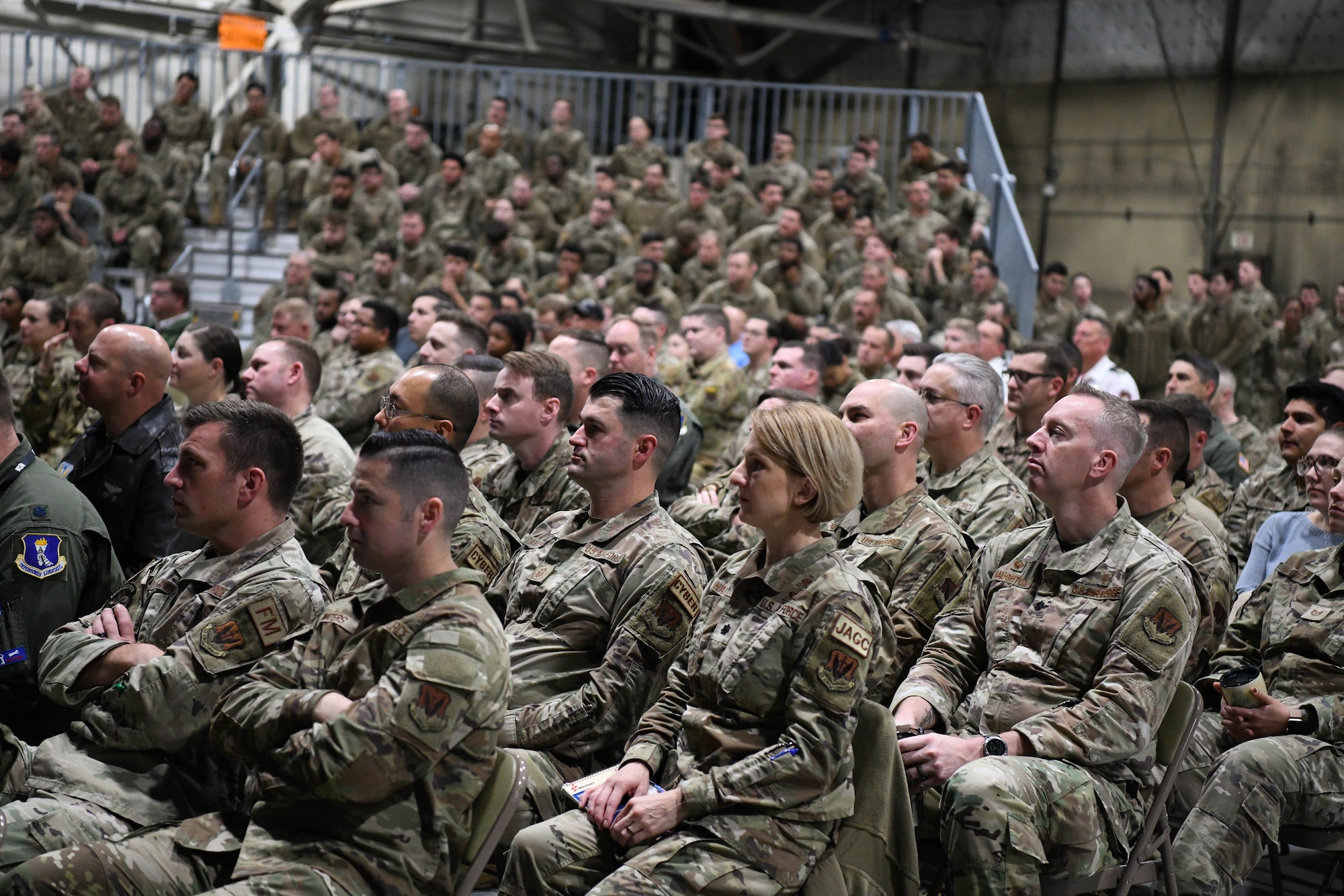 Military members sit in rows of chairs.
