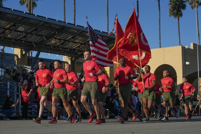 U.S. Marines with Bravo Company, 1st Recruit Training Battalion, Recruit Training Regiment, carry the colors during a motivational run at Marine Corps Recruit Depot San Diego, Oct. 5, 2023. The motivational run is the last physical training event Marines conduct while at MCRD San Diego before they graduate. (U.S. Marine Corps photo by Lance Cpl. Francisco Angel)