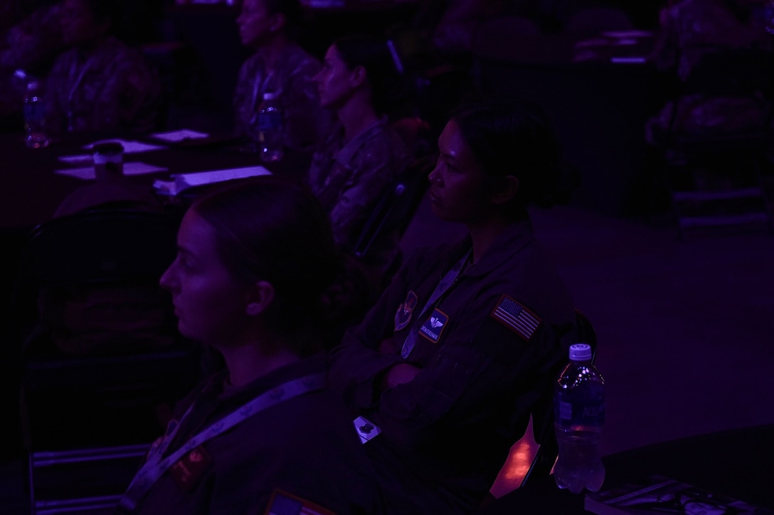 Audience members listening to a panel at Torch Athena