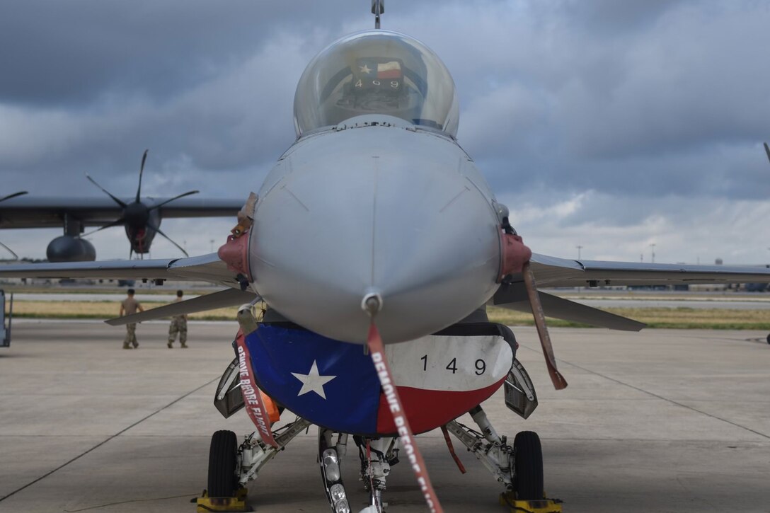 The front view of an F-16 with a Texan flag-themed intake cover.
