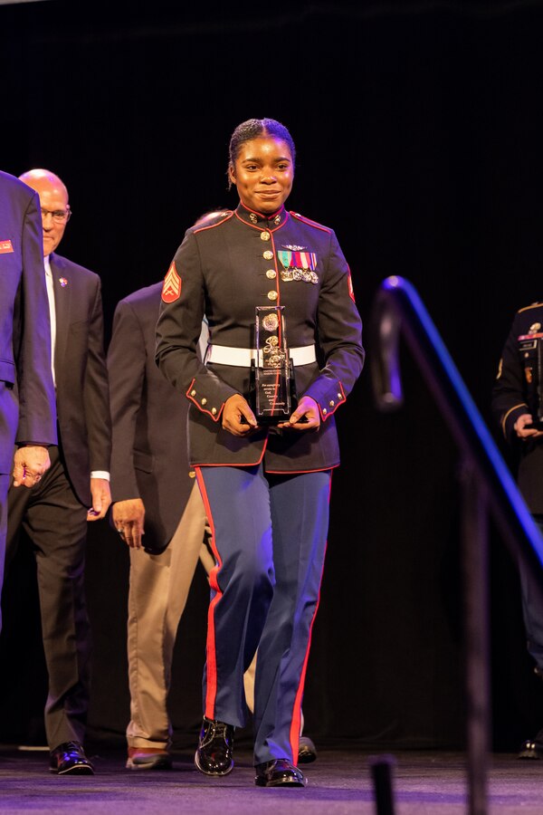 U.S. Marine Corps Sgt. Nhatalyne Bordes, a legal chief, office of the Staff Judge Advocate, with Headquarters and Headquarters Squadron, Marine Corps Air Station New River, walks with her award during the 104th American Legion National Convention in Charlotte, North Carolina, Aug. 29, 2023. Bordes received the 2023 American Legion Spirit Service Award for the U.S. Marine Corps. (U.S. Marine Corps photo by Cpl. Jennifer E. Douds)