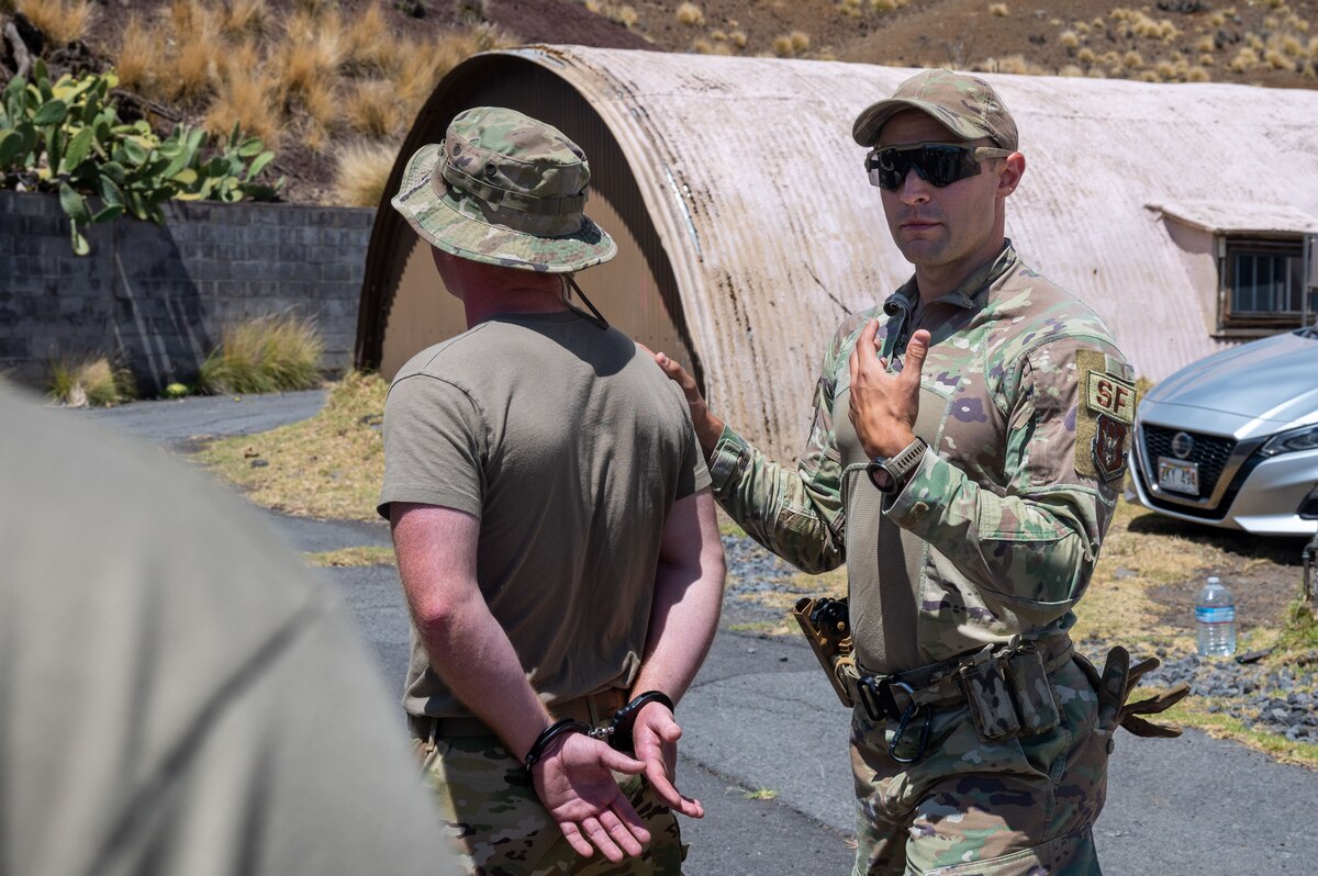 Security Forces Airmen handcuffs another Airmen during a training event.