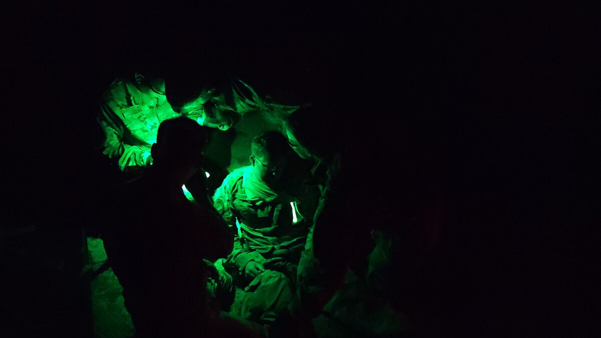 Airmen work on patient triage and movement during a night time training event.