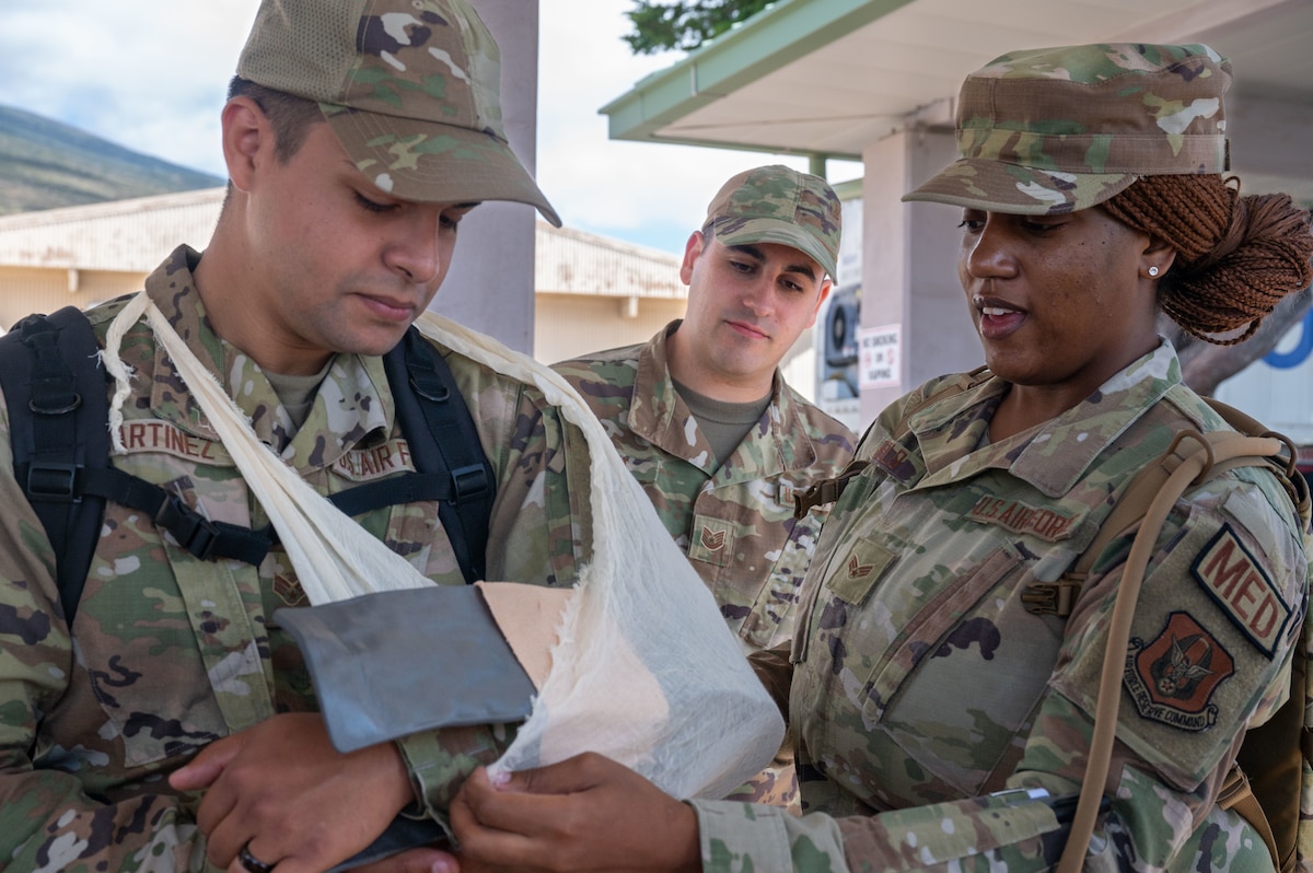 Medical Airman shows proper splinting techniques on another Airman.