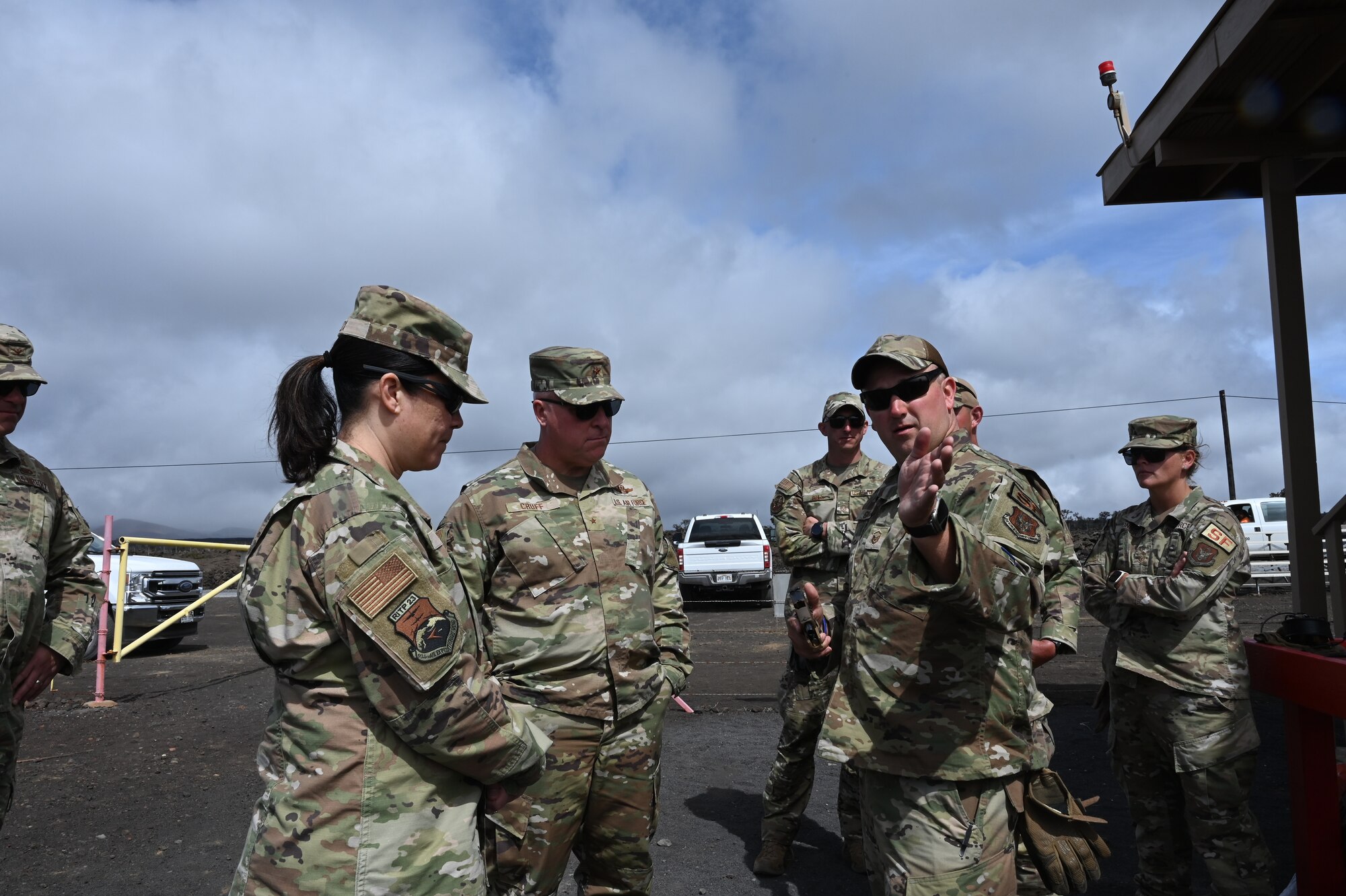 One Airman explains firearms safety to two senior Airmen.