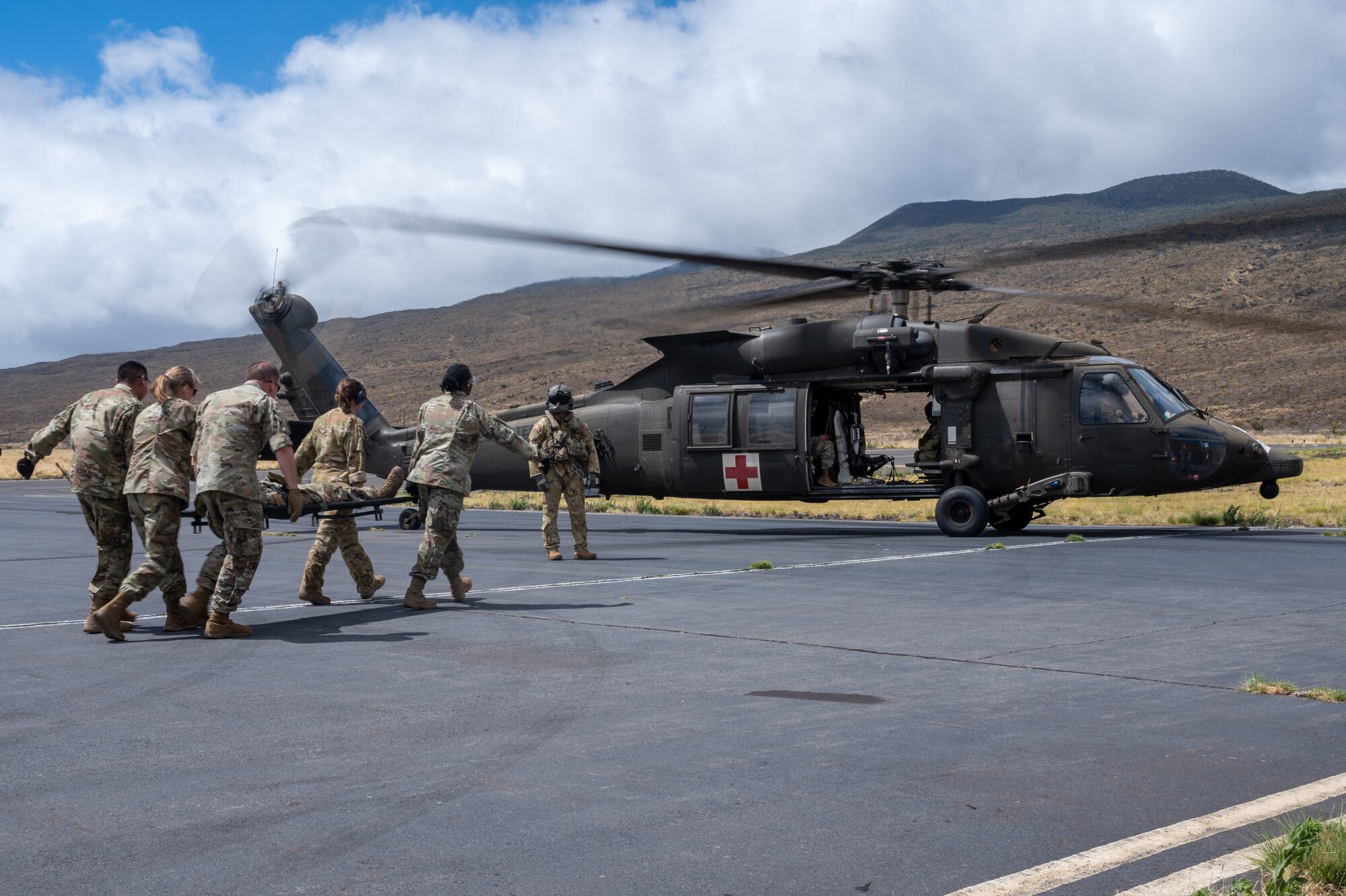 Medical Airmen transport a patient to an Army helicopter.