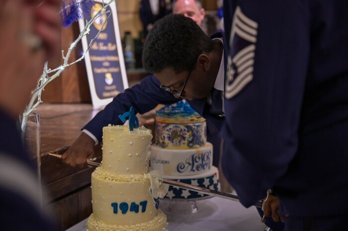 The youngest Airman cuts the cake.