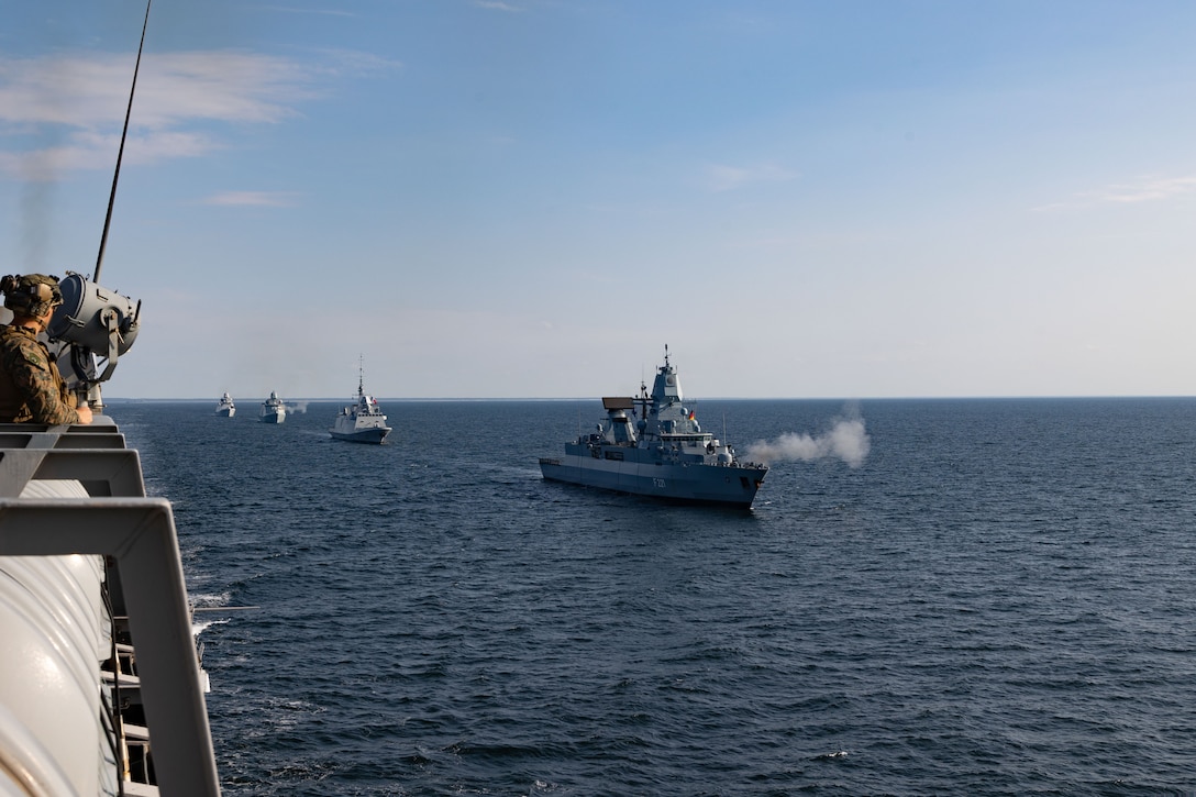 Naval war ships from multiple nations fire their weapons while in formation near the USS Mesa Verde (LPD 19) during Northern Coast 2023 (NoCo 23), Sept. 18, 2023. NoCo 23 is a German-led multinational exercise that strengthens military and maritime combat readiness through realistic training in order to sharpen interoperability with our Allies and partners. The San Antonio-class amphibious transport dock ship USS Mesa Verde (LPD 19), assigned to the Bataan Amphibious Ready Group and embarked 26th Marine Expeditionary Unit (Special Operations Capable), under the command and control of Task Force 61/2, is on a scheduled deployment in the U.S. Naval Forces Europe area of operations, employed by U.S. Sixth Fleet to defend U.S., Allies, and partner interests. (U.S. Marine Corps photo by Cpl. Michele Clarke)