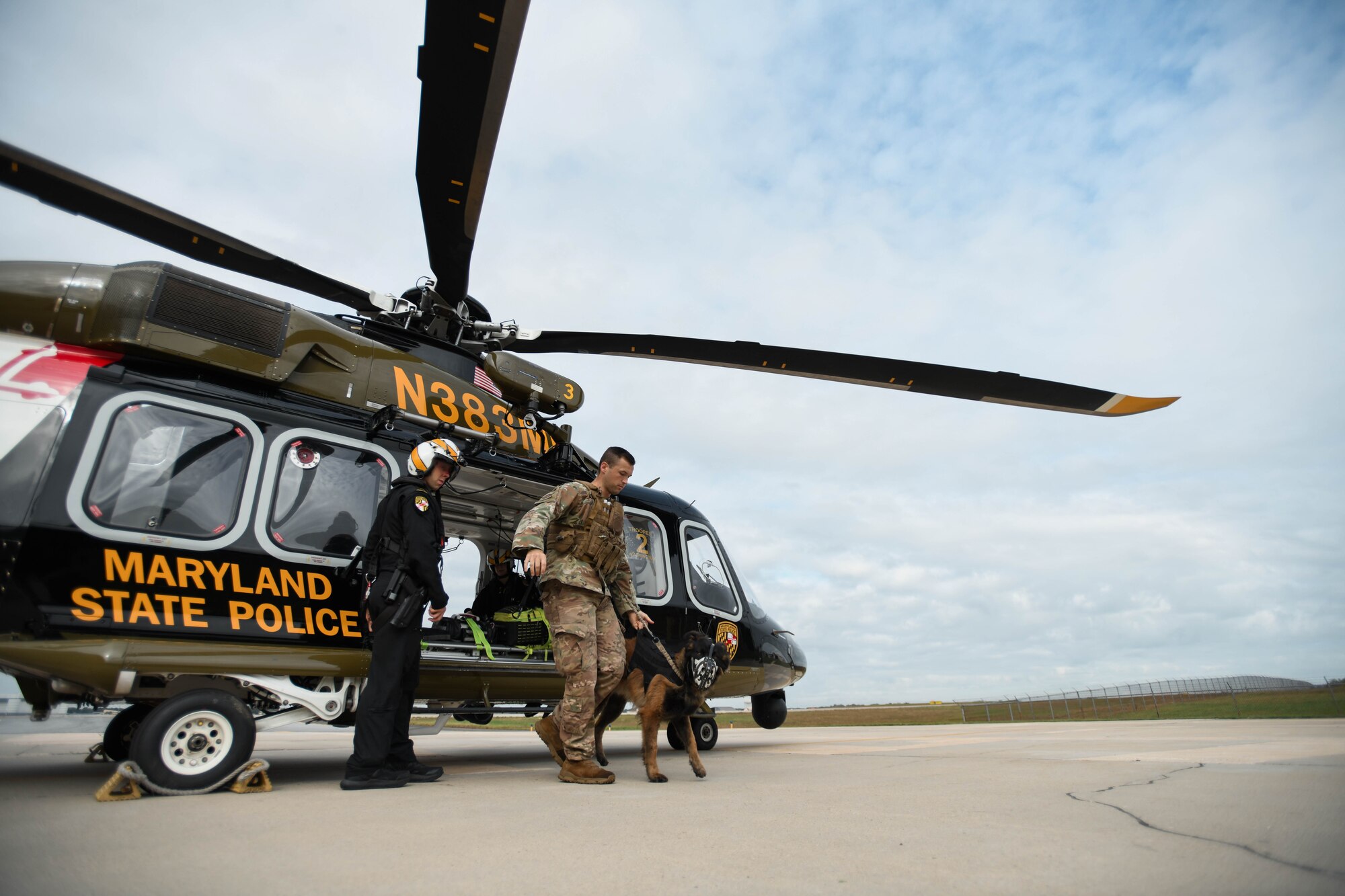 Man and dog exit a helicopter.