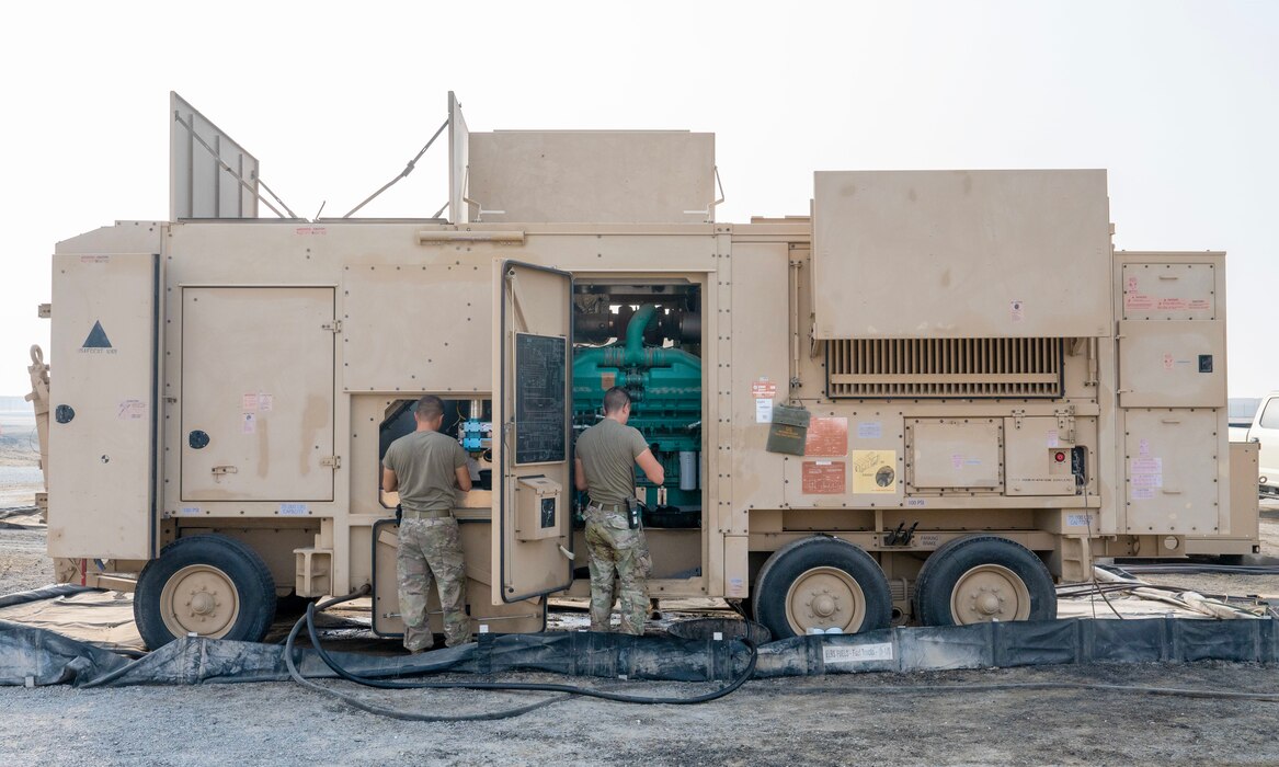 A photo of two Airmen working on a generator.