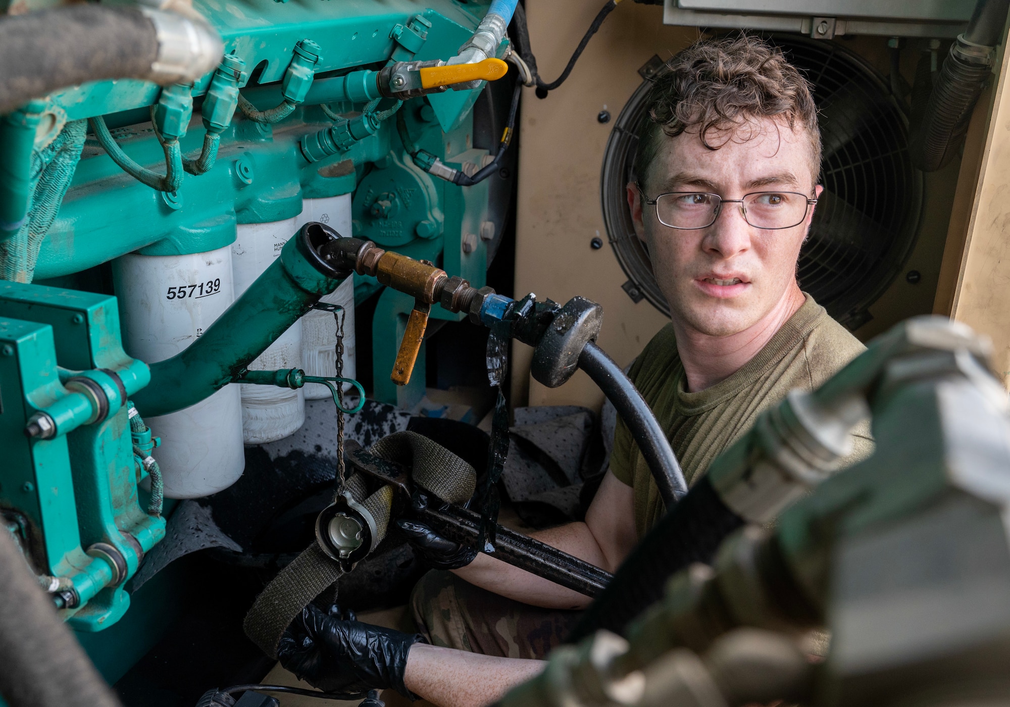 A photo of an Airman crouched inside a generator.