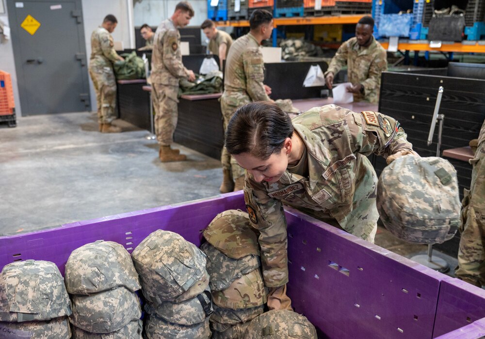 A photo of an Airman placing a helmet into a bin.